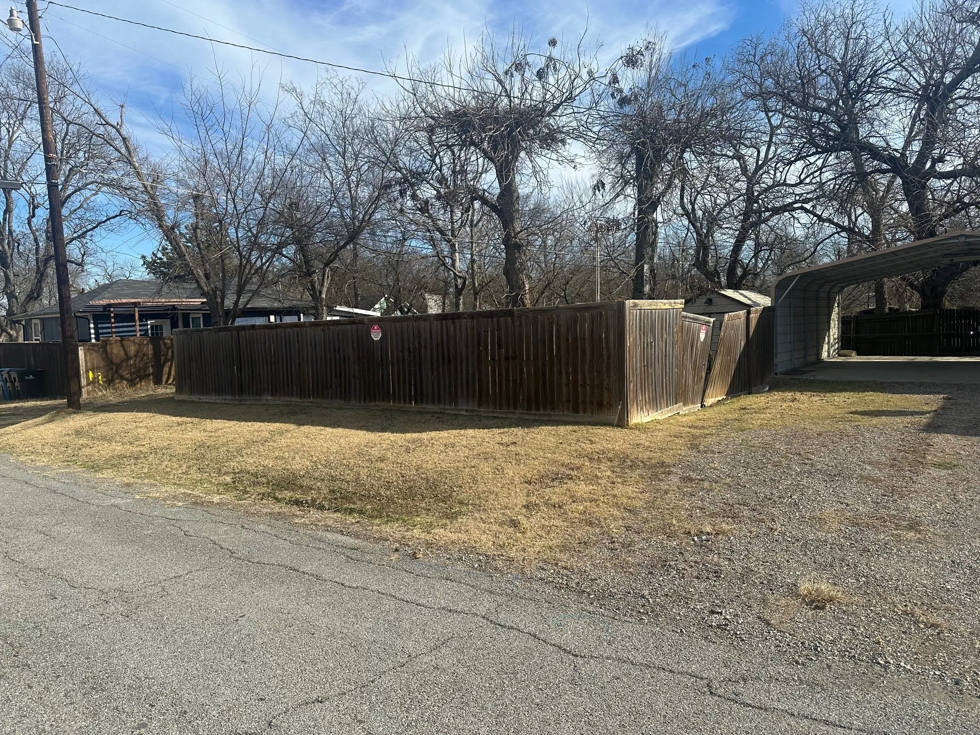 Covered carport and wood fence with metal posts