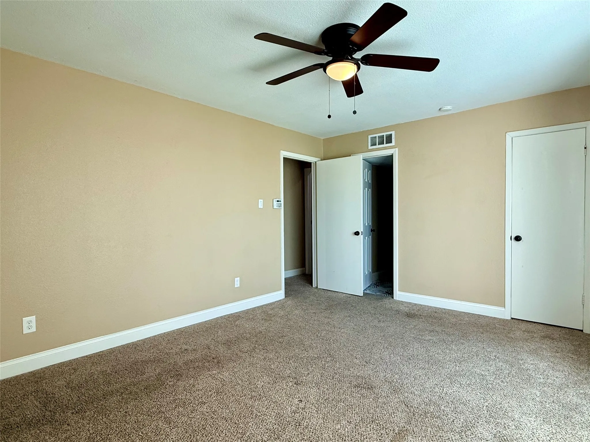 Unfurnished bedroom featuring carpet floors, a ceiling fan, and a textured ceiling