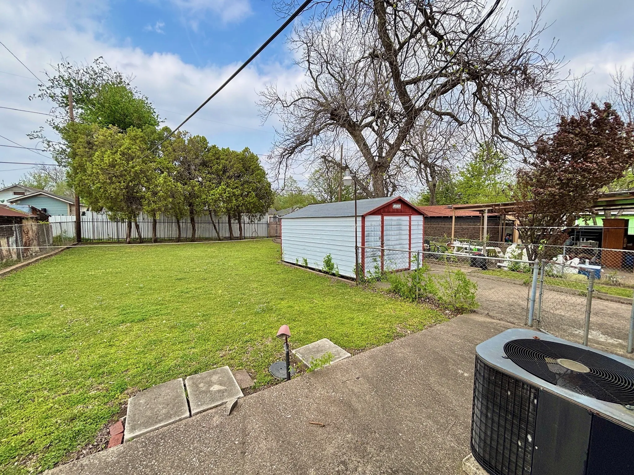 Fenced backyard featuring a storage shed