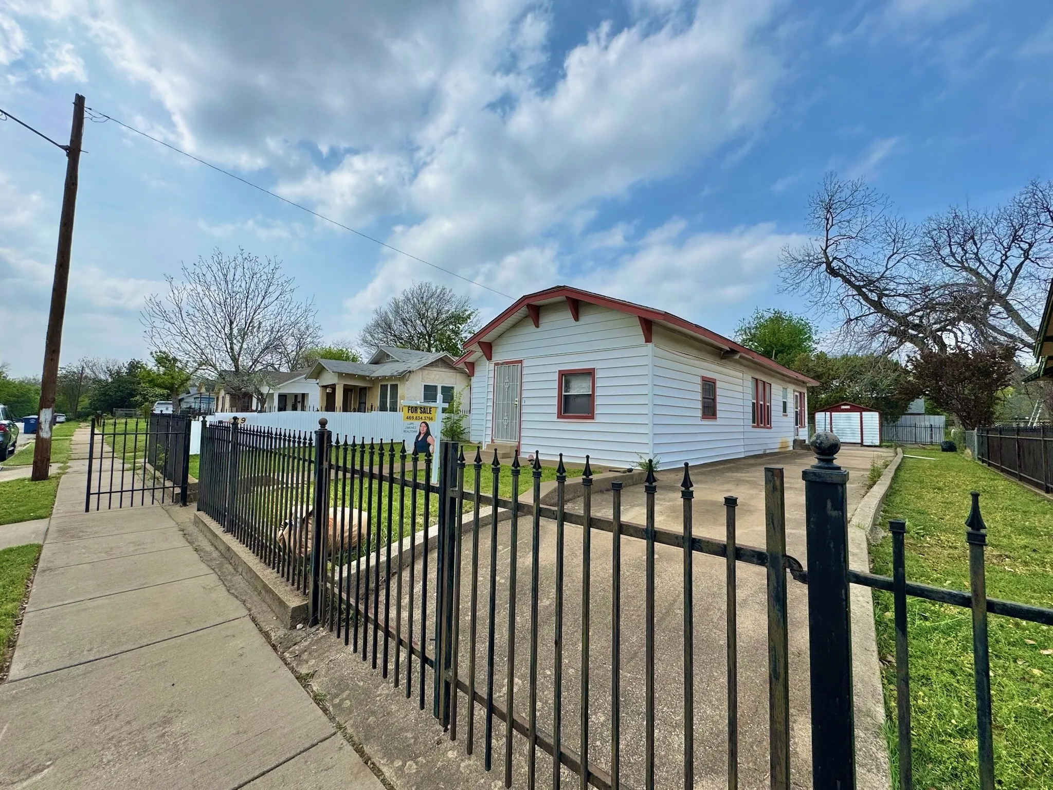 View of front facade featuring a fenced front yard, a gate, and a residential view