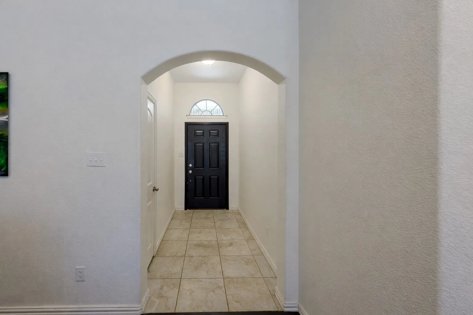 Doorway to outside with arched walkways and tile patterned flooring