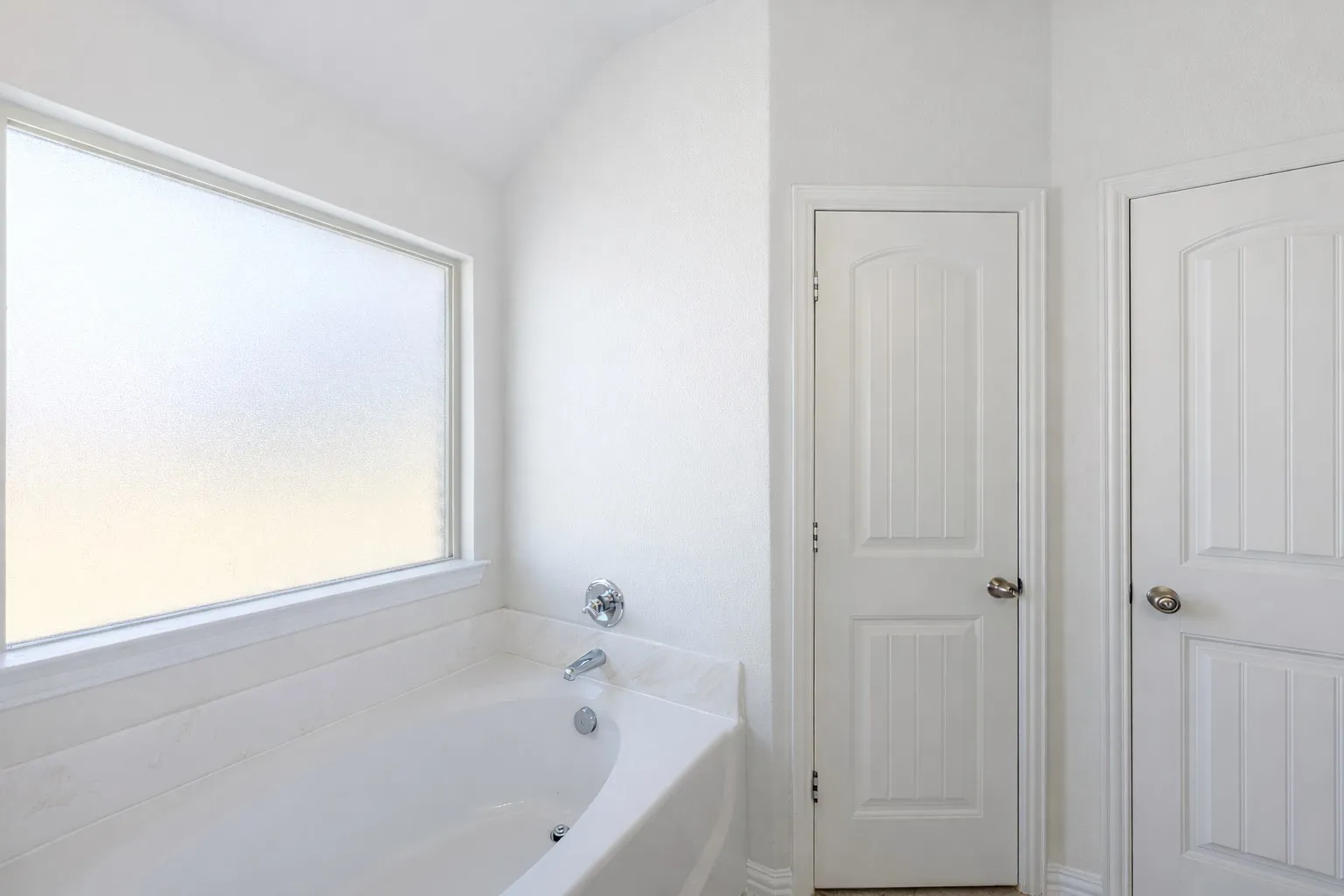 Full bathroom with a garden tub and vaulted ceiling