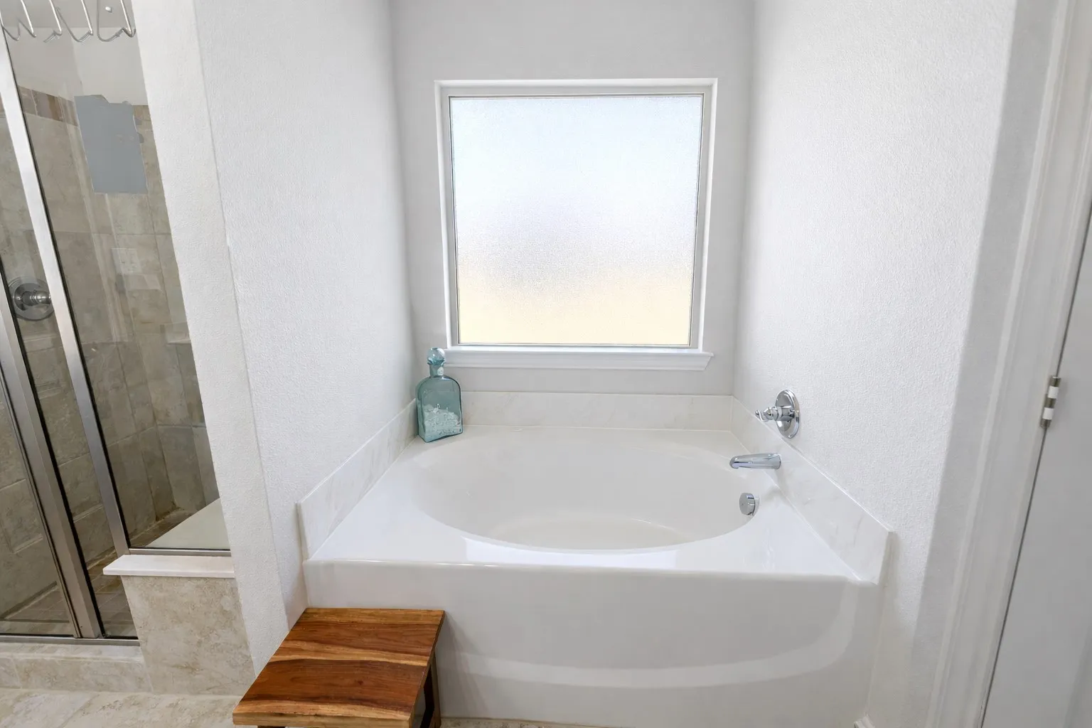 Full bath with a garden tub, a shower stall, and a textured wall