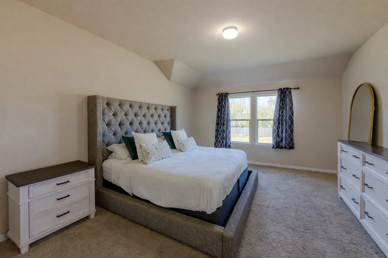 Bedroom featuring lofted ceiling and light carpet