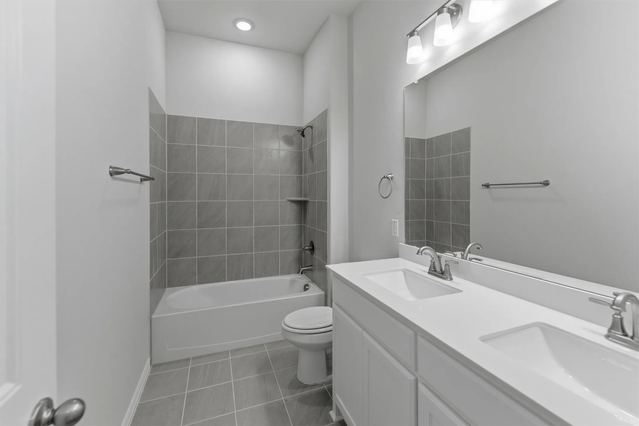 Dual sink vanity with white cabinetry and integrated countertops