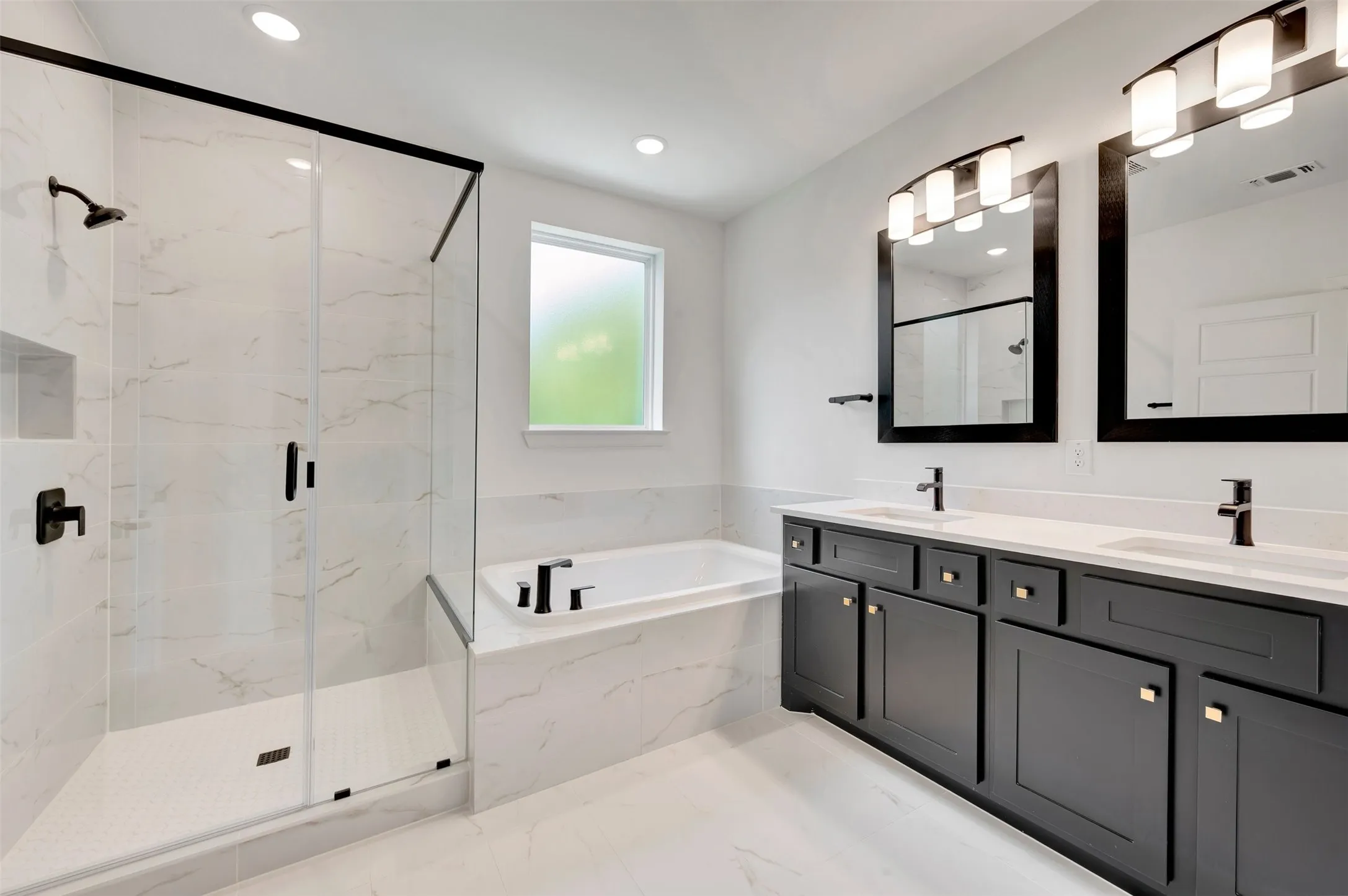 Contemporary bathroom featuring a spacious walk-in shower with black-framed glass enclosure, a built-in soaking tub, and a double vanity with dark cabinetry