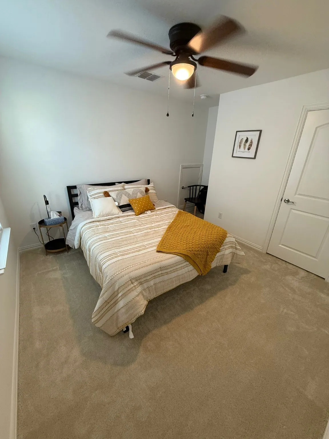Carpeted bedroom with a ceiling fan and baseboards