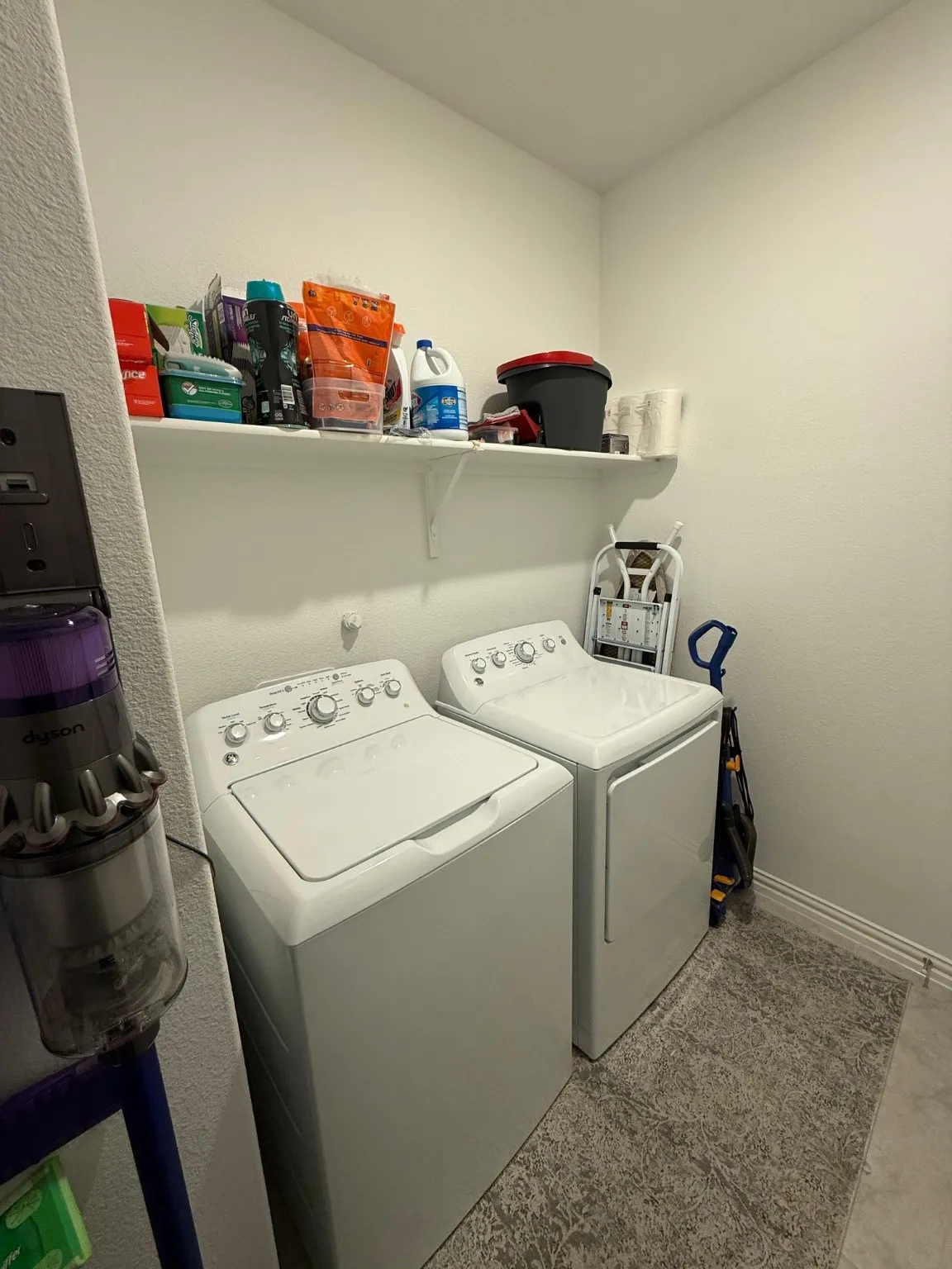 Laundry area with washer and dryer and a textured wall
