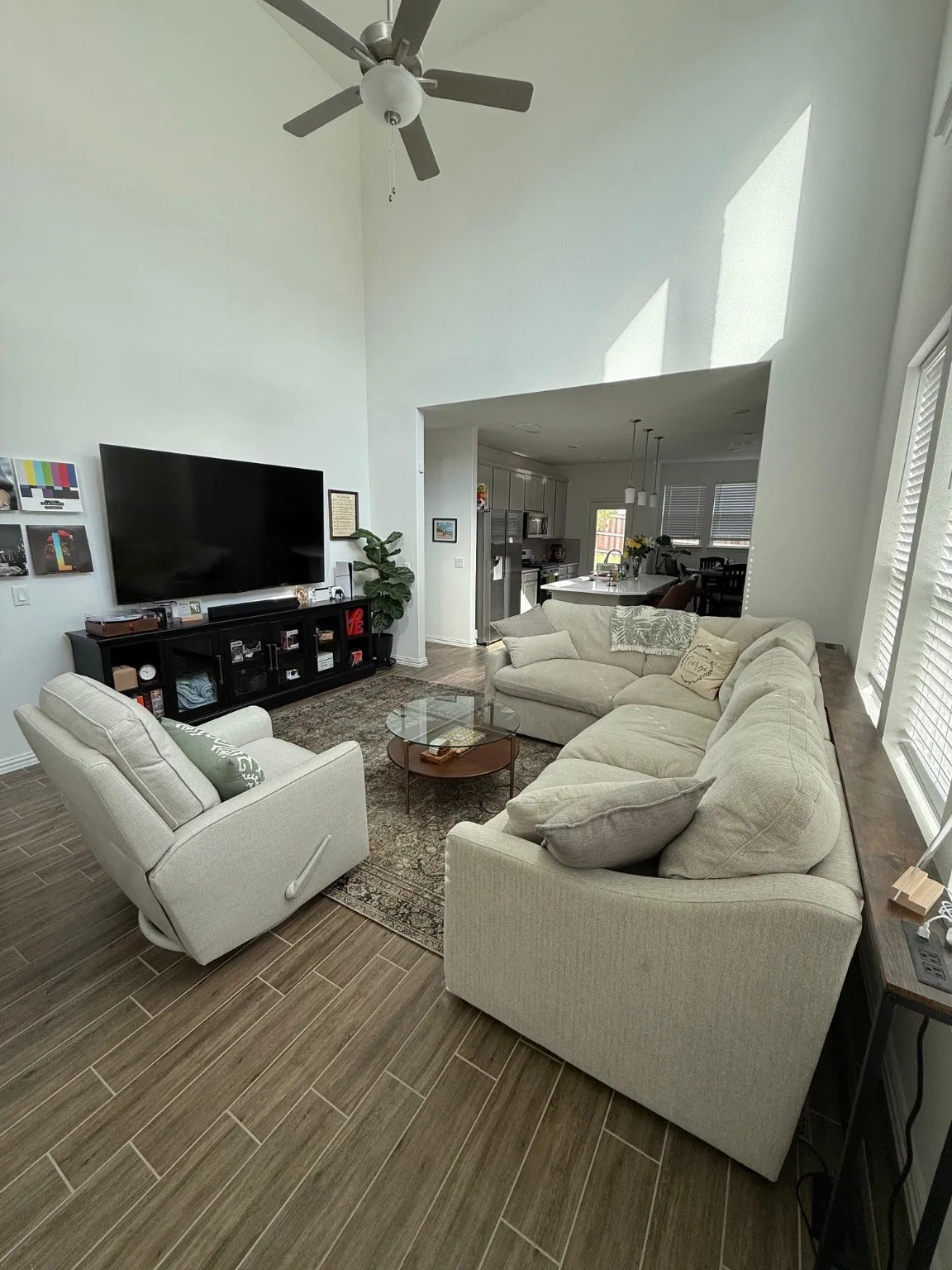 Living room featuring a towering ceiling, wood tiled floors, and a ceiling fan