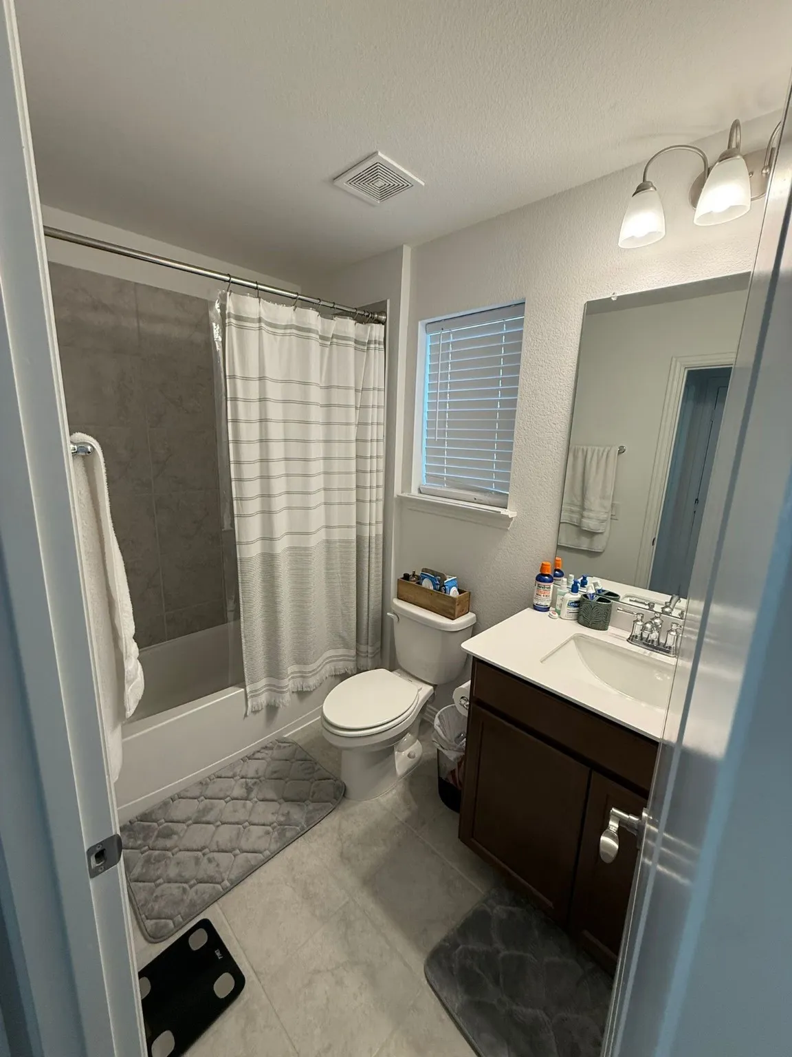 Full bath featuring shower / bathtub combination with curtain, vanity, a textured wall, a textured ceiling, and light tile patterned flooring