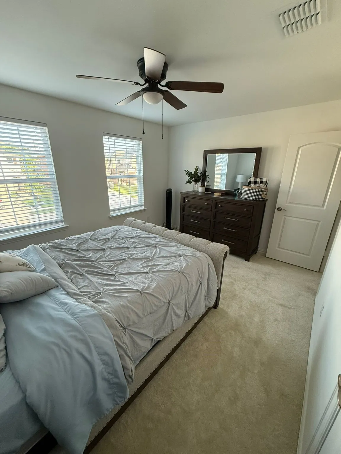 Carpeted bedroom with a ceiling fan