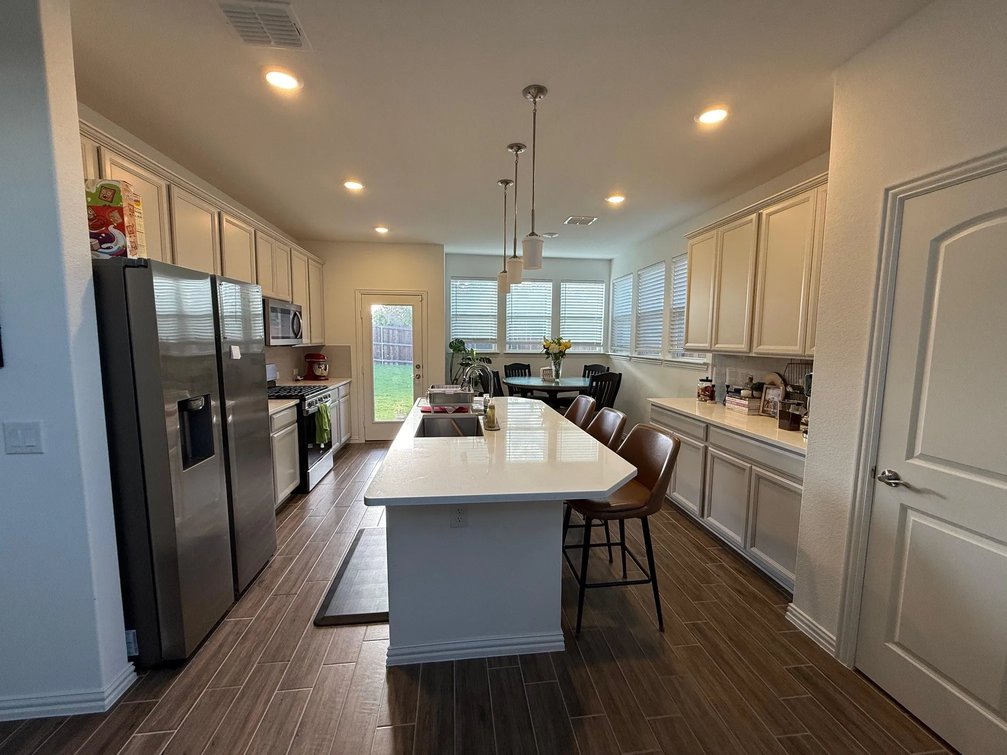Kitchen with a breakfast bar area, appliances with stainless steel finishes, wood tiled floors, pendant lighting, and recessed lighting