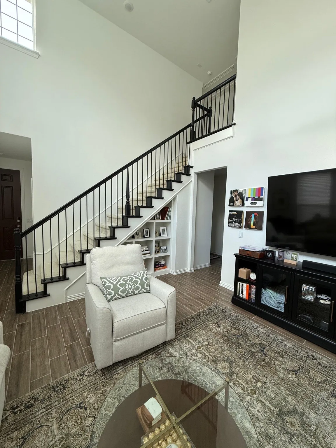 Living area featuring stairway, a towering ceiling, and wood finish floors