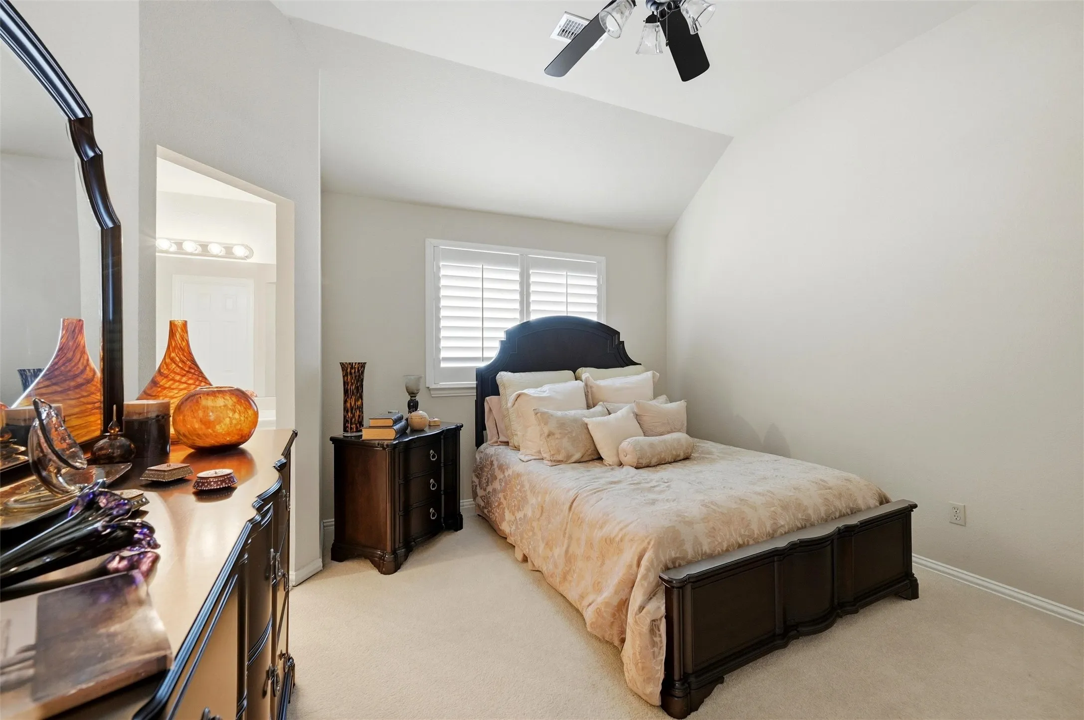 Bedroom with lofted ceiling, light colored carpet, and a ceiling fan