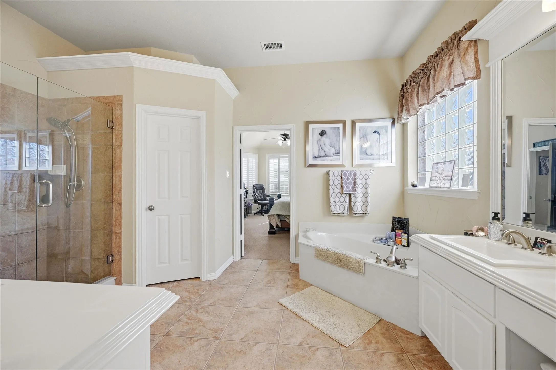 Ensuite bathroom featuring vanity, a shower stall, light tile patterned floors, a bath, and a ceiling fan