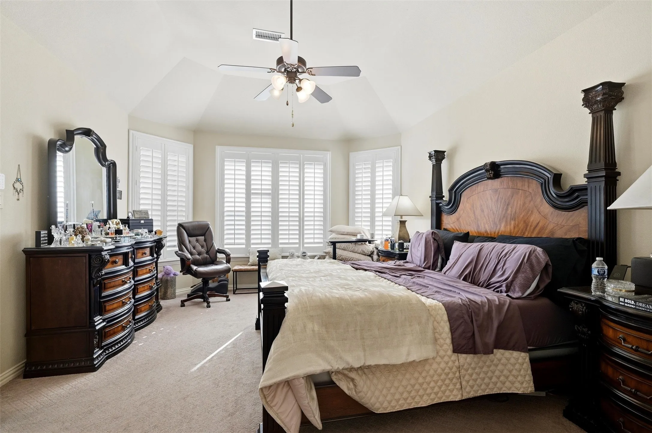 Carpeted bedroom with lofted ceiling and a ceiling fan