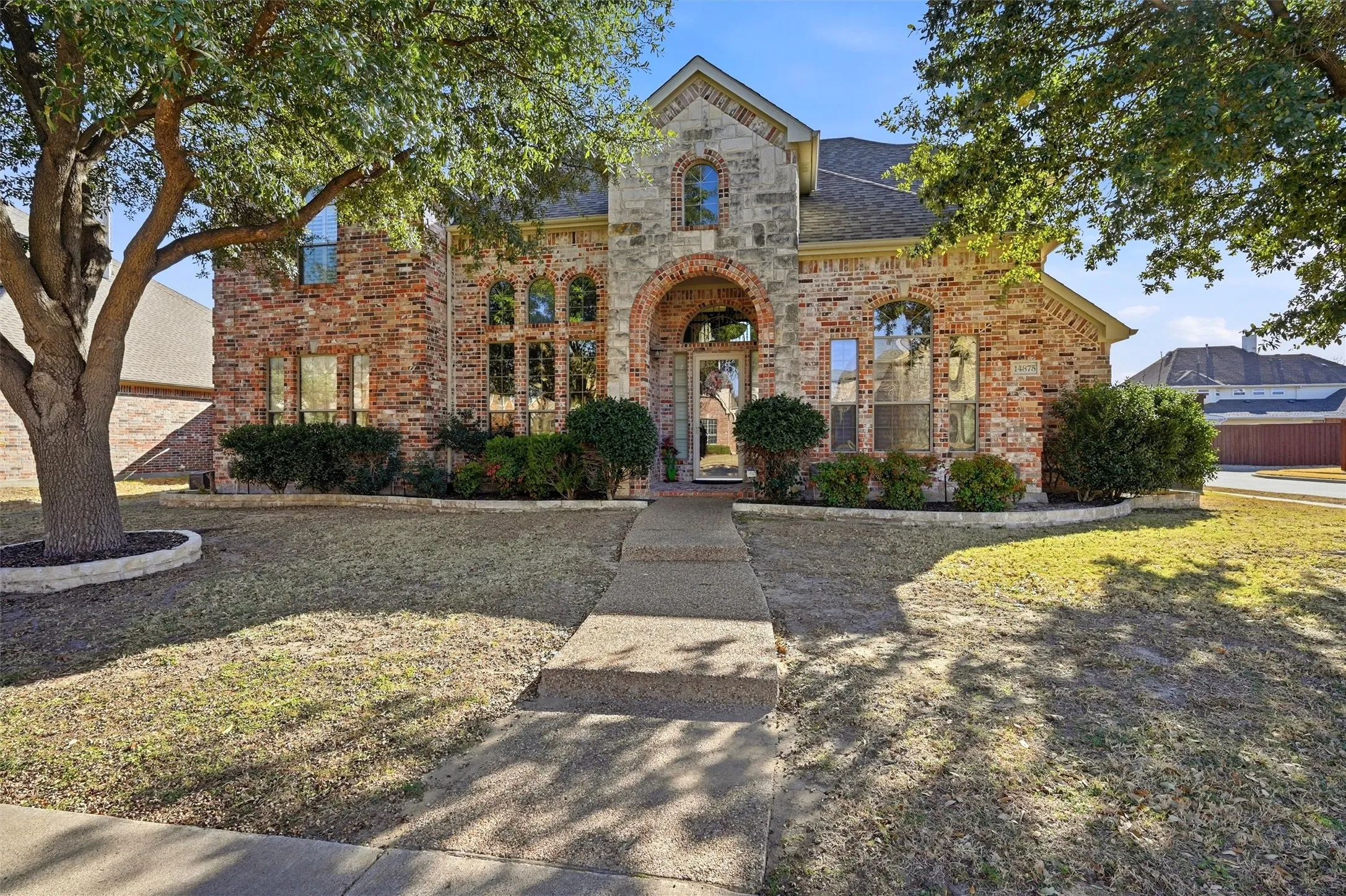 French country style house featuring brick siding, a shingled roof, and a front lawn