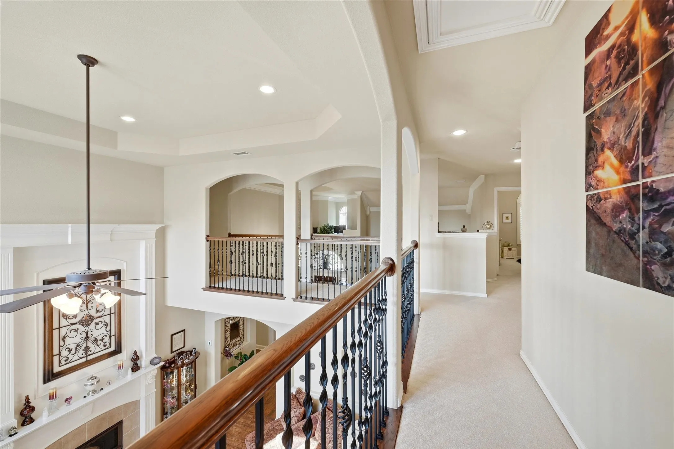 Hallway with a raised ceiling, carpet, recessed lighting, and an upstairs landing