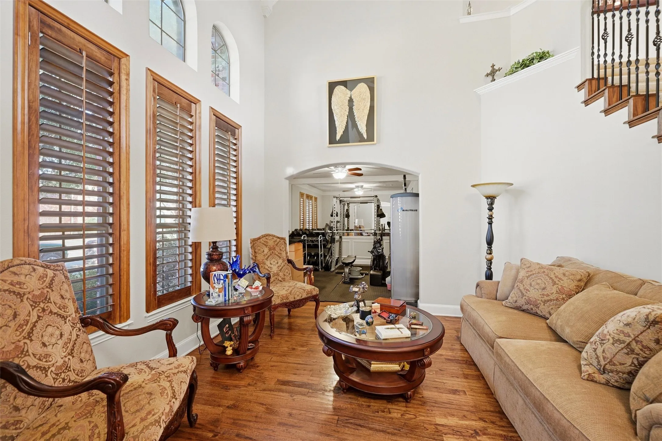 Living area featuring arched walkways, hardwood / wood-style floors, and a towering ceiling