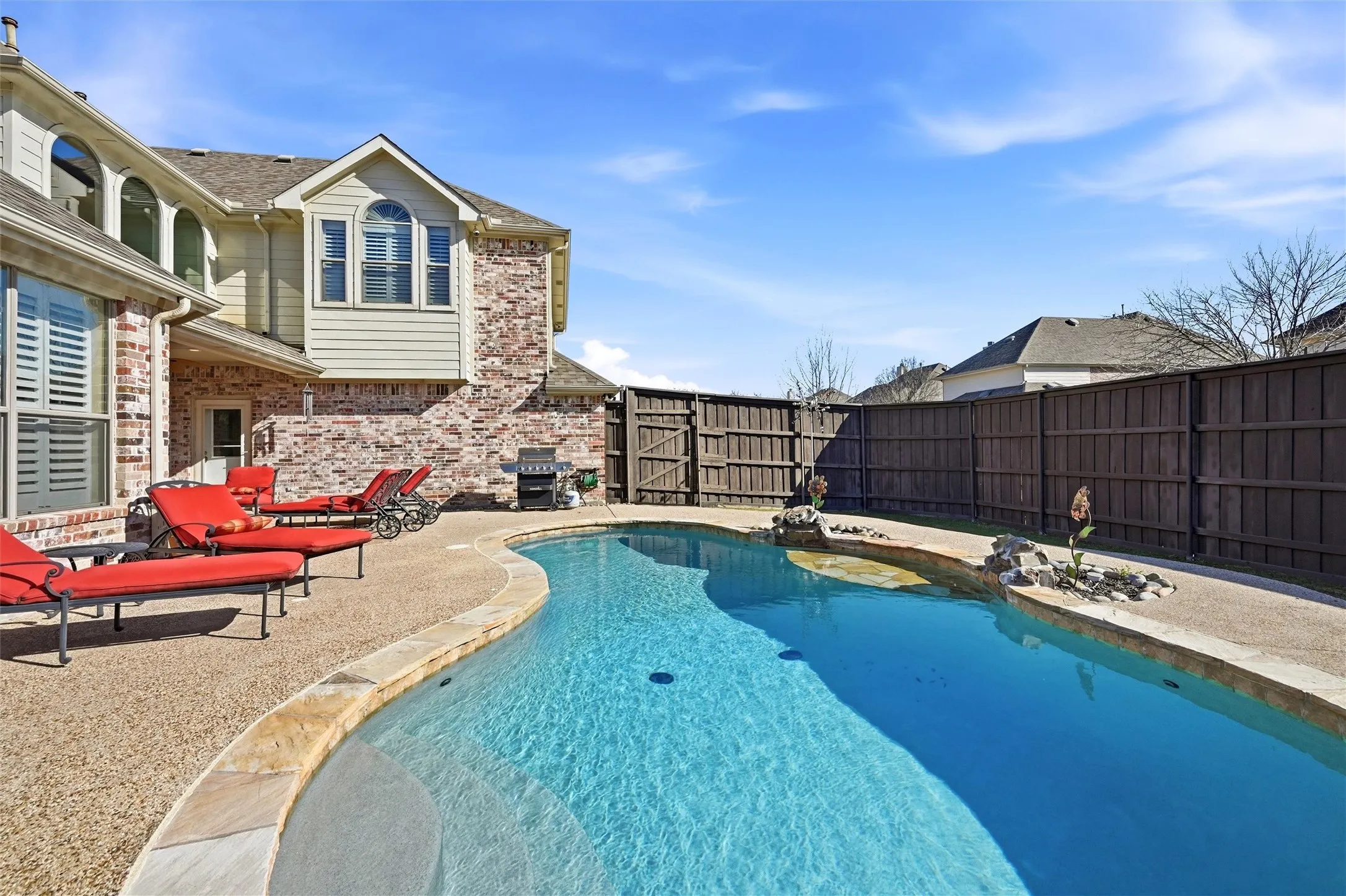 View of pool featuring a patio area, a fenced backyard, and area for grilling