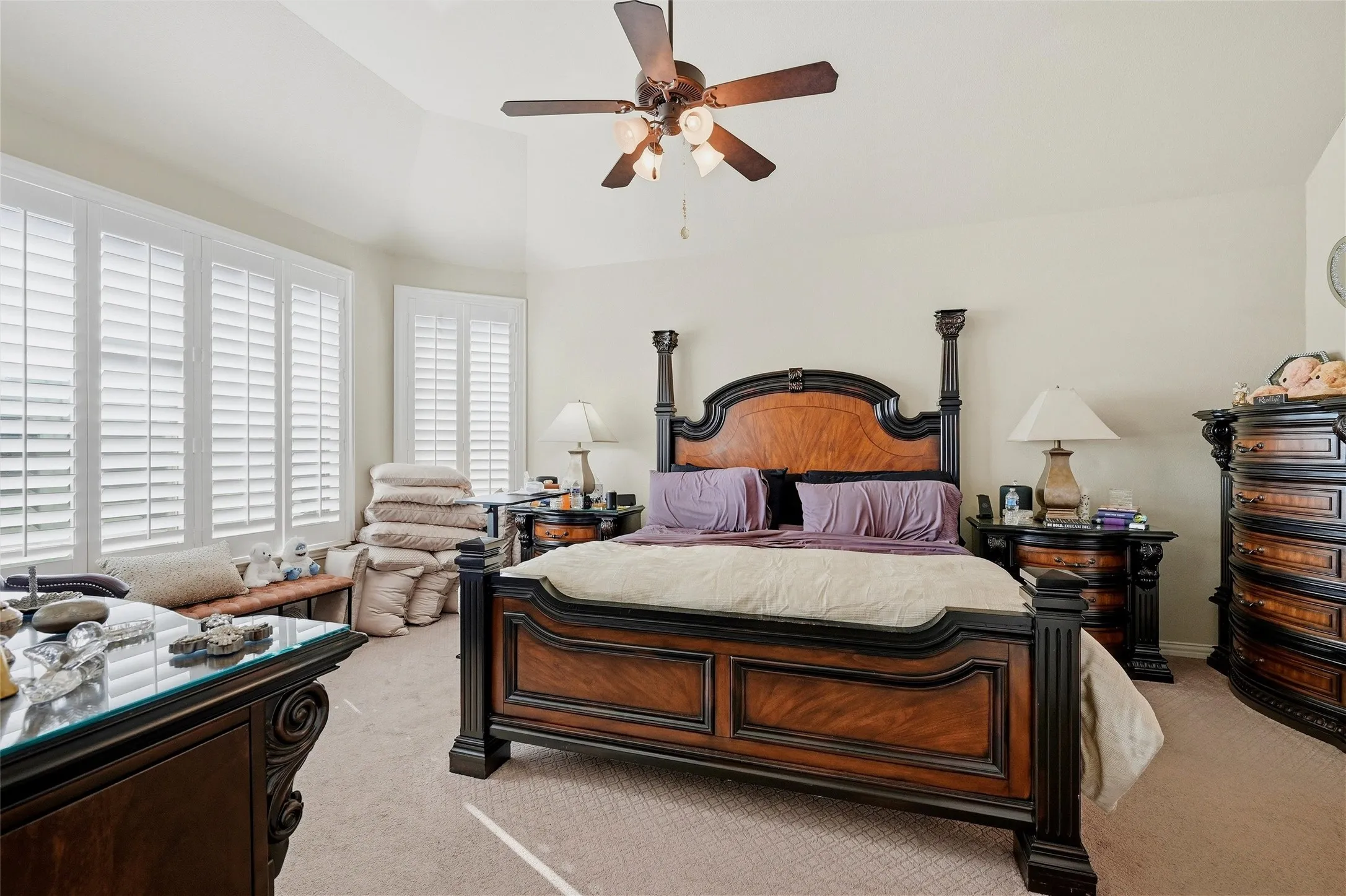Bedroom featuring light carpet, ceiling fan, and vaulted ceiling