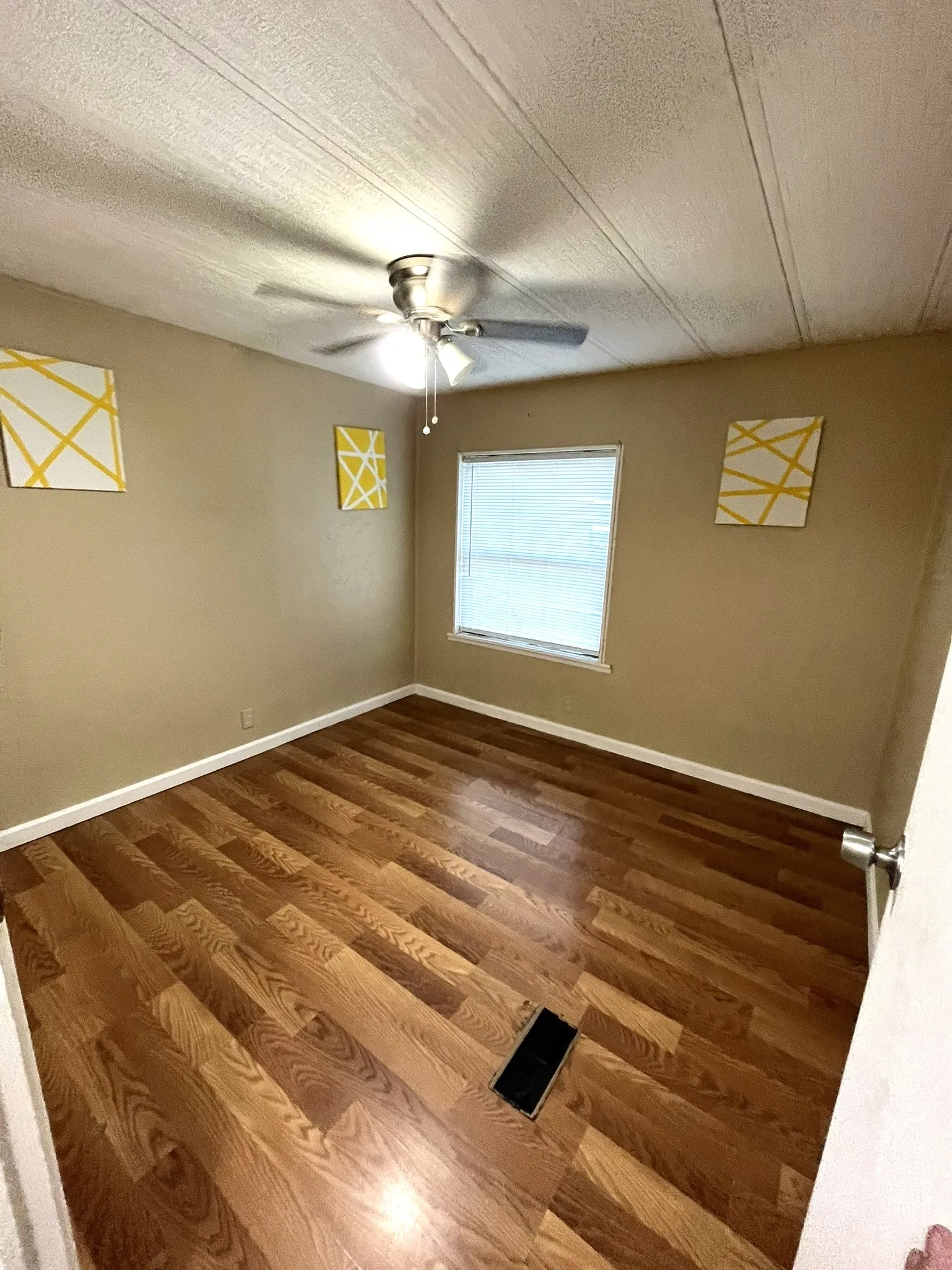 Spare room with a textured ceiling and dark wood-type flooring