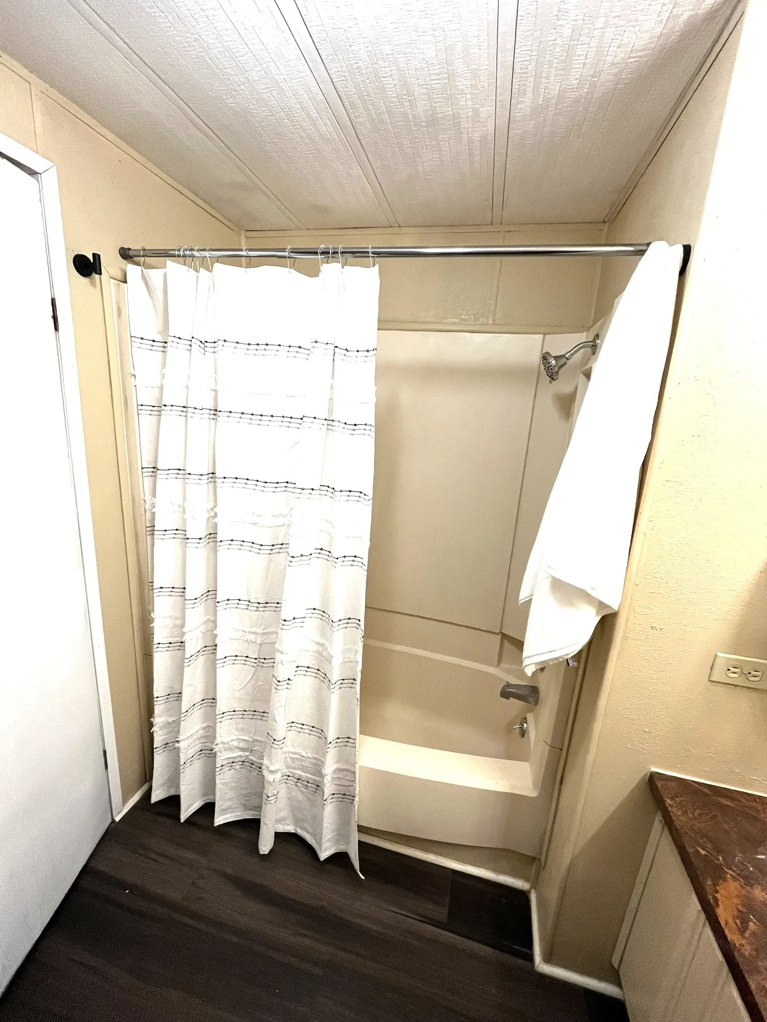 Bathroom with shower / bath combination with curtain, dark wood finished floors, and vanity
