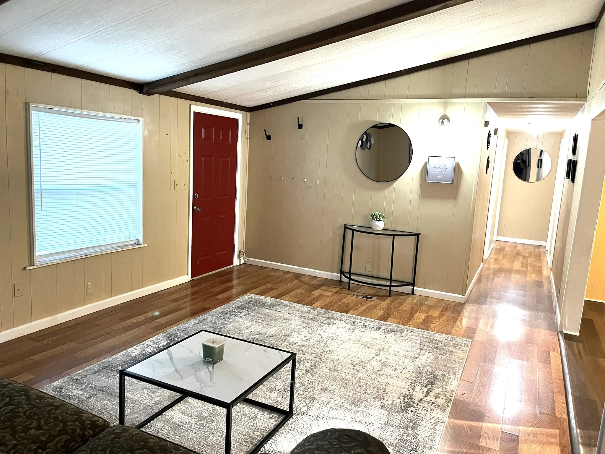 Unfurnished living room with wooden walls and wood finished floors
