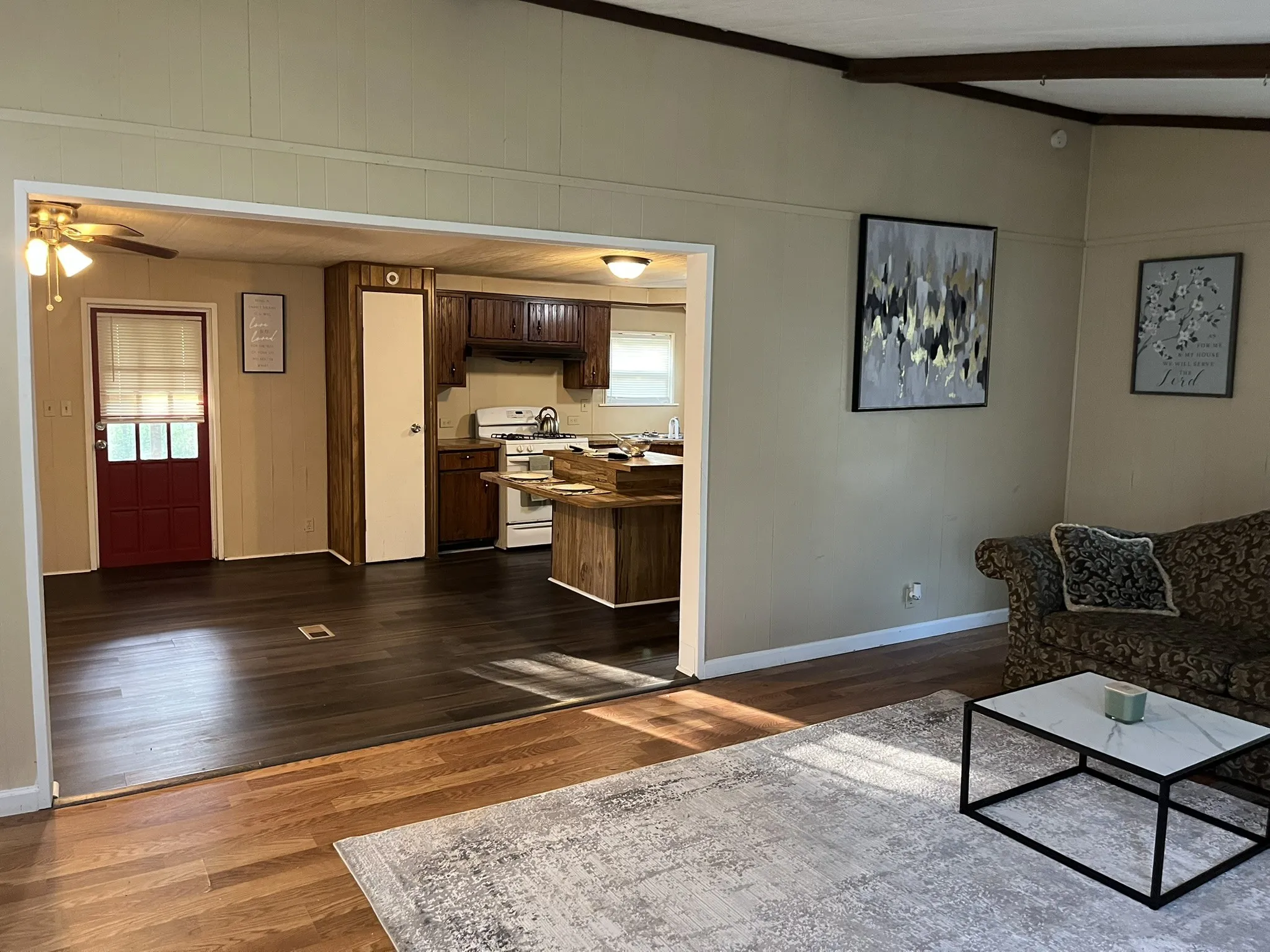 Living room featuring dark wood-style floors and a ceiling fan