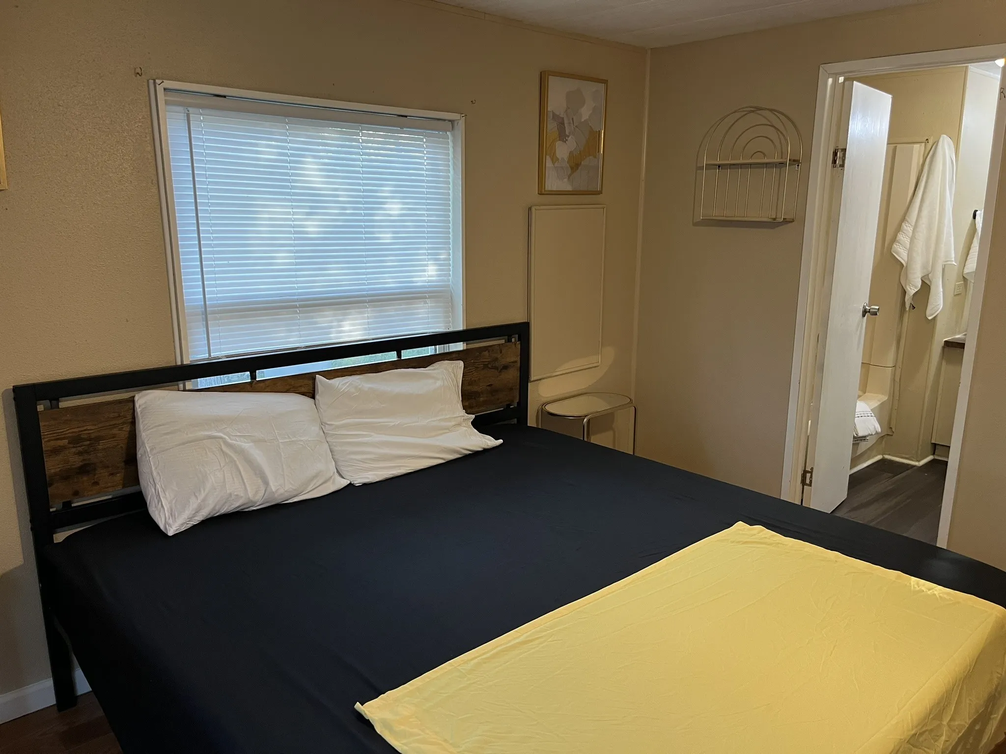 Bedroom with connected bathroom and dark wood-style flooring