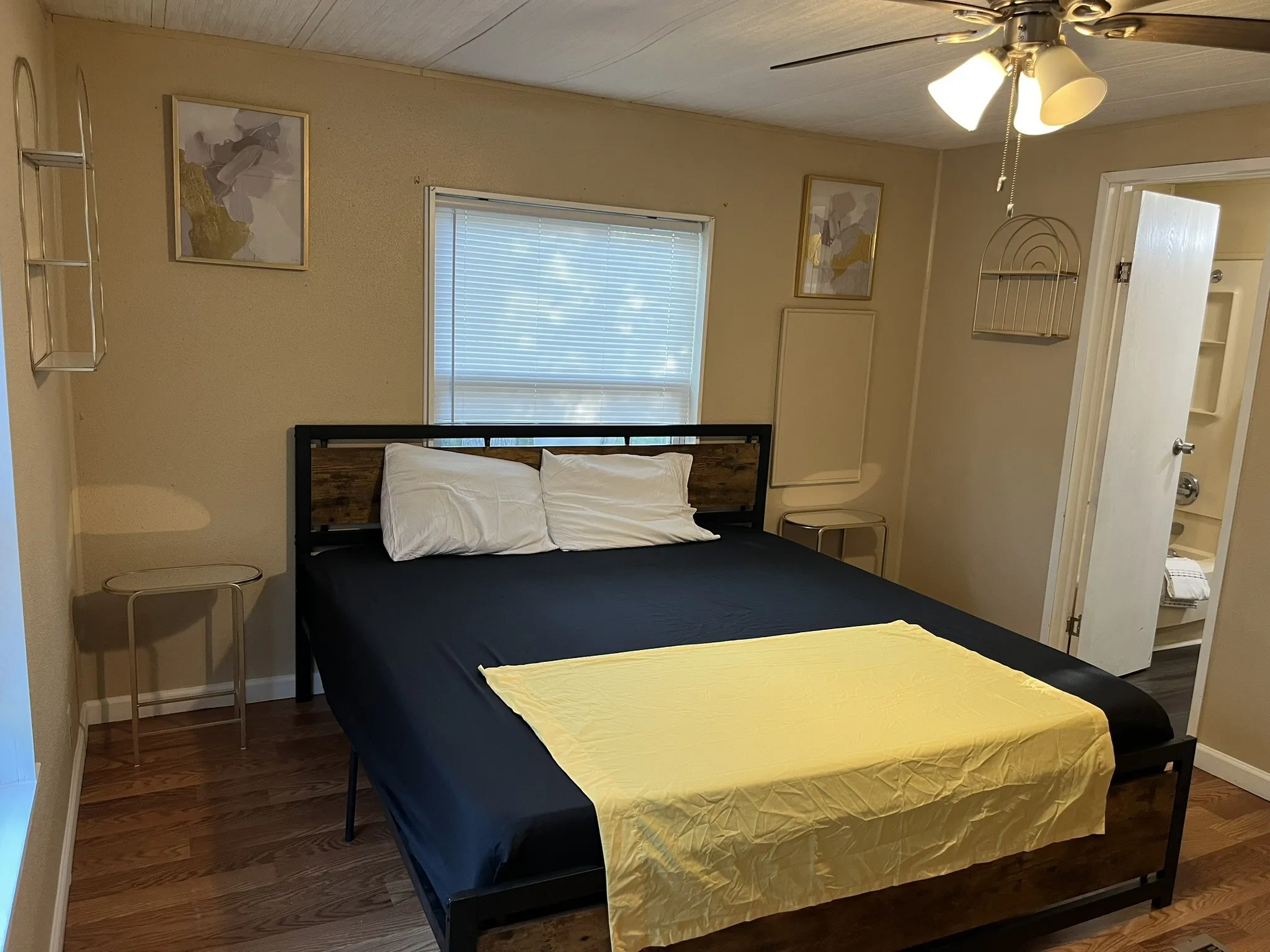 Bedroom with a ceiling fan, dark wood-type flooring, and ensuite bath