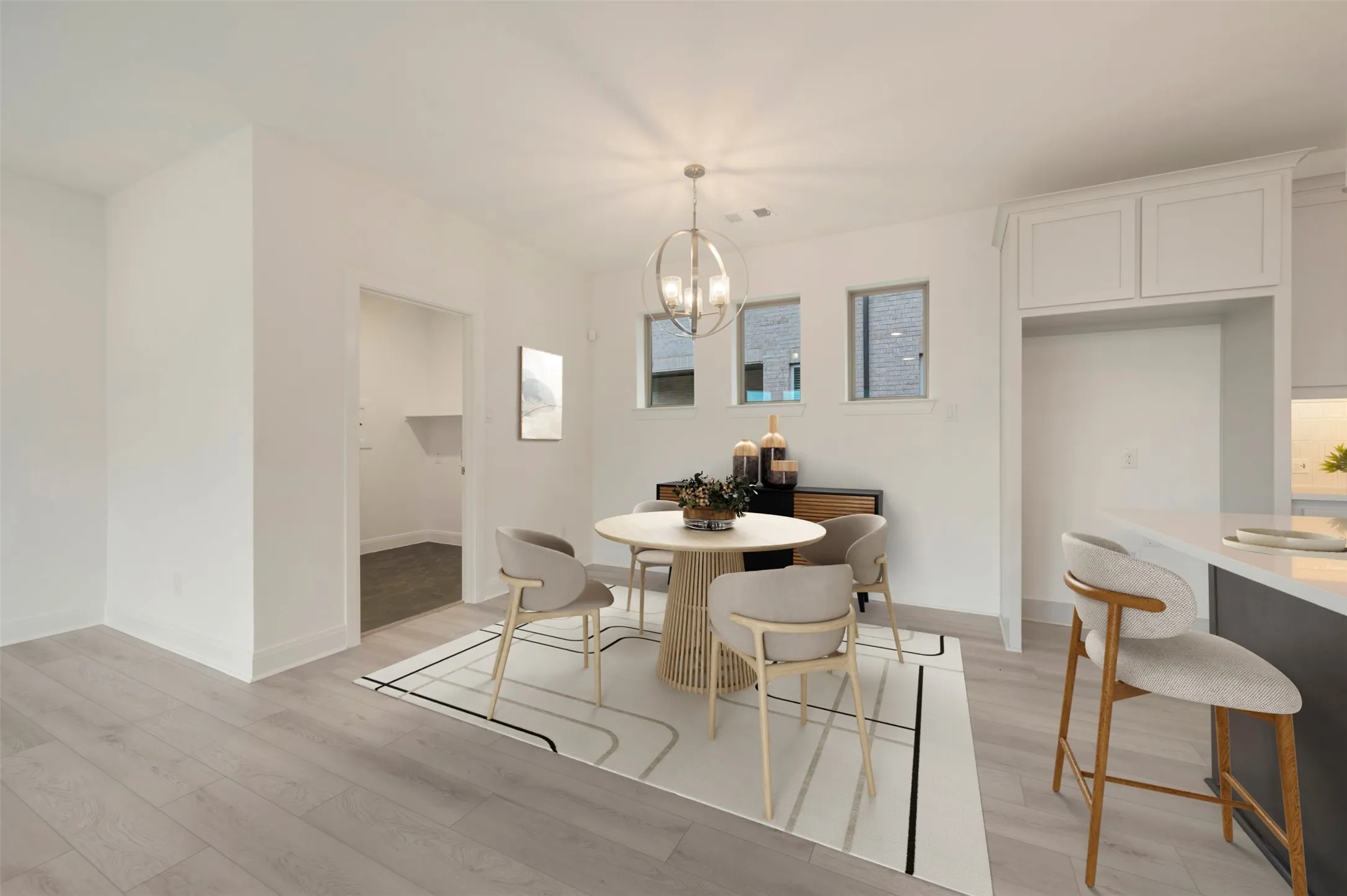 Open dining area featuring wood-finish flooring, a contemporary spherical chandelier, and three transom windows