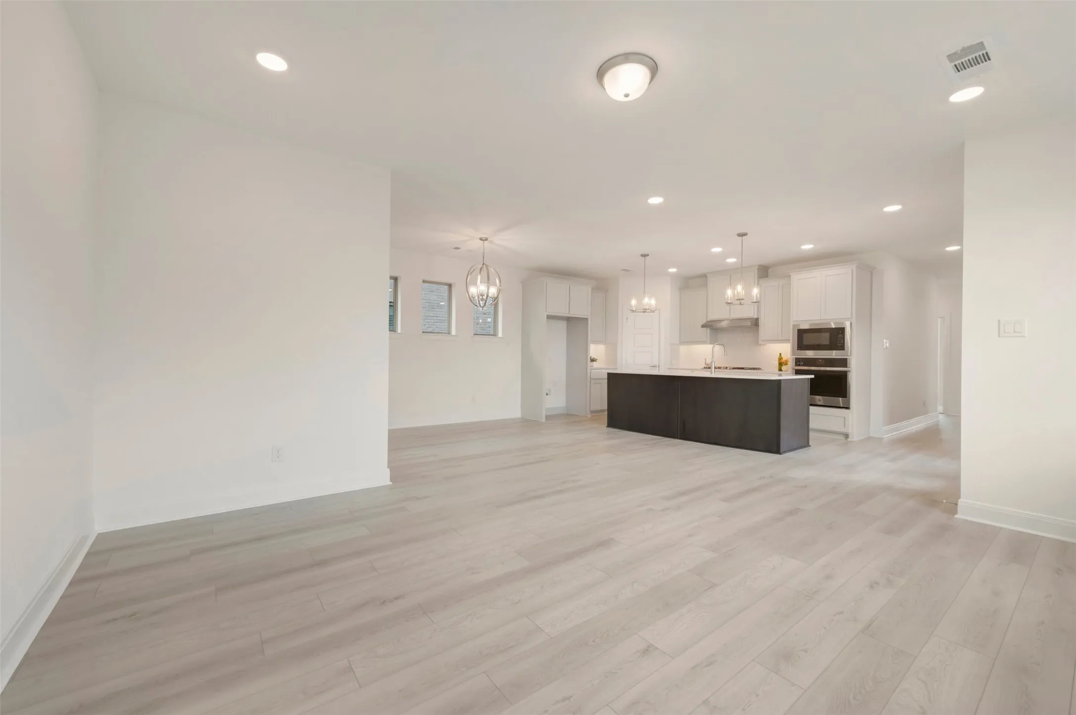 Open-concept living area featuring light wood-finish flooring throughout