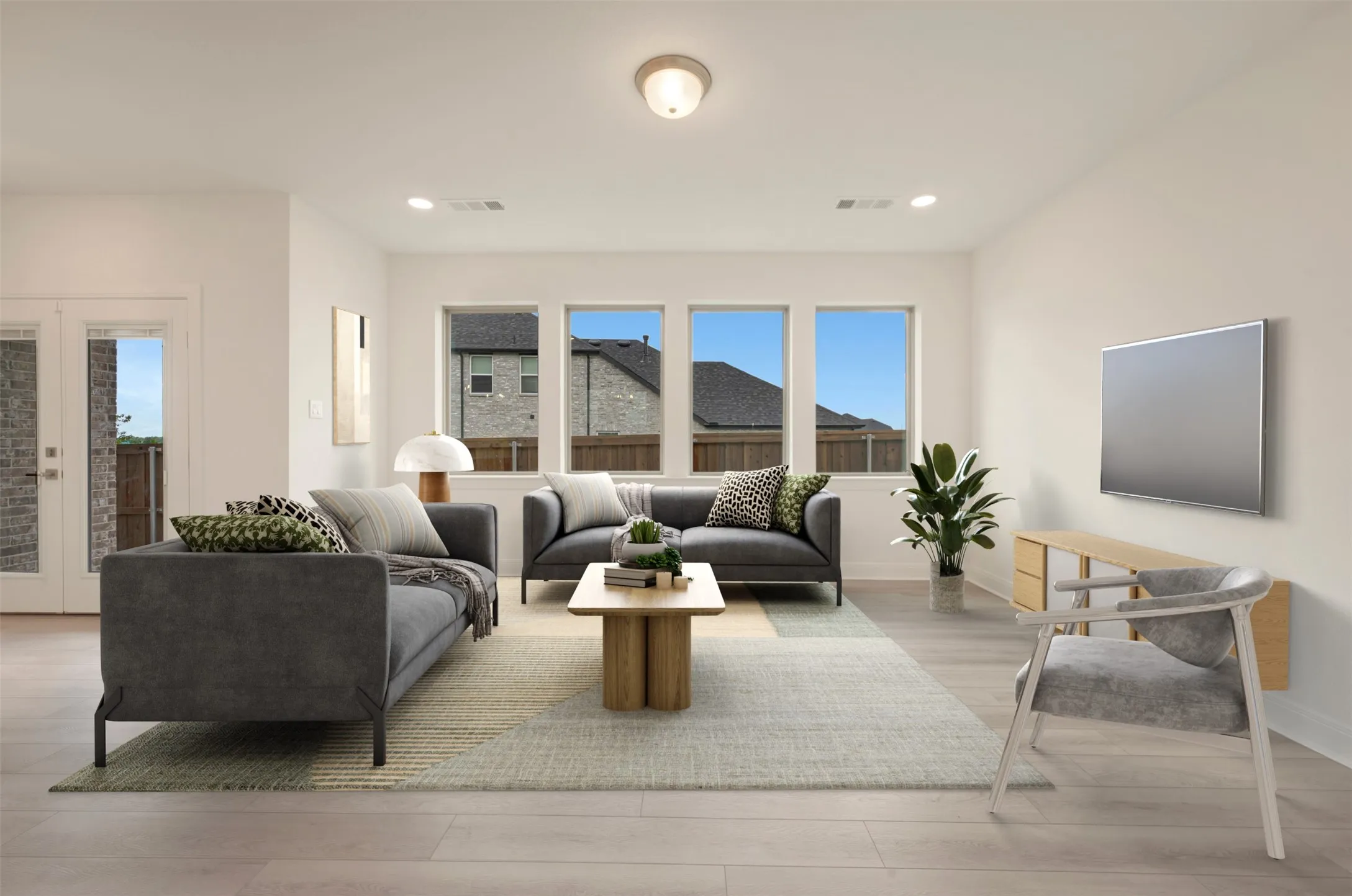 Spacious living area featuring light wood-finish flooring and neutral wall tones