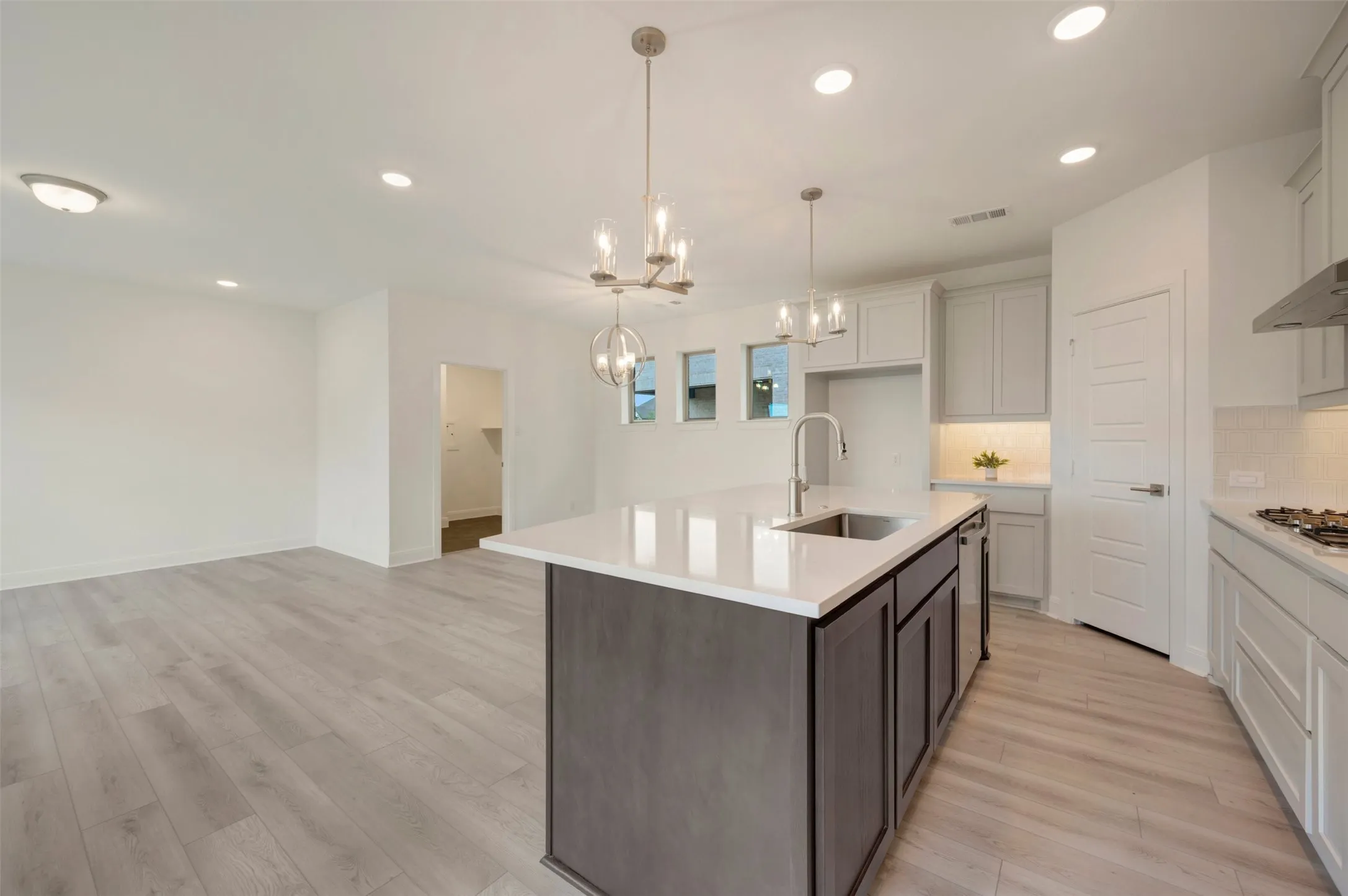 Open-concept living space with light wood-finish flooring