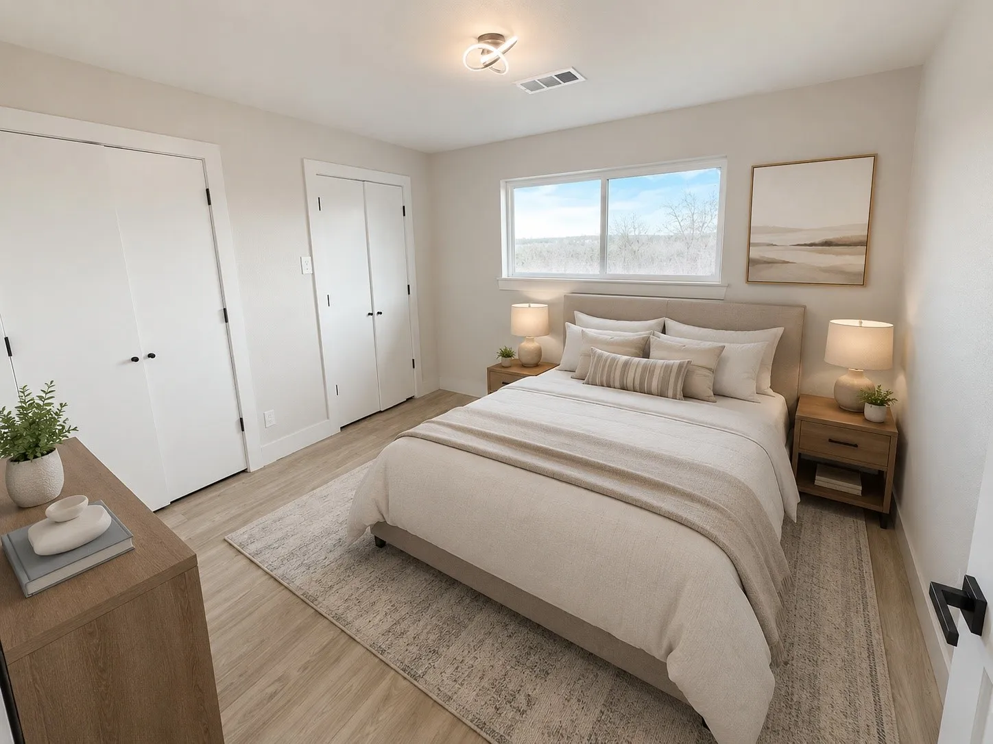 Bright interior featuring wood-finish flooring, a contemporary ceiling light fixture, and two sets of bi-fold closet doors