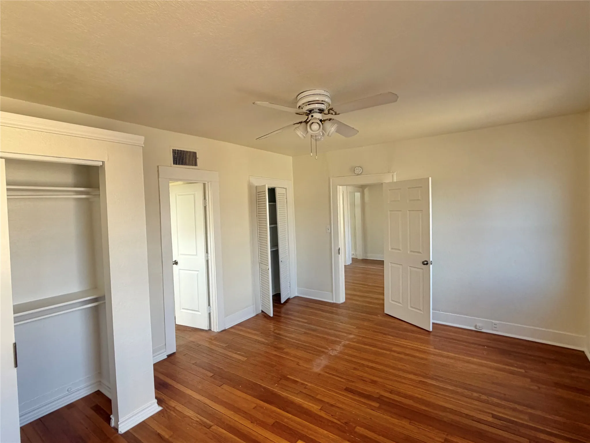 Hardwood flooring, ceiling fan, and built-in closet storage