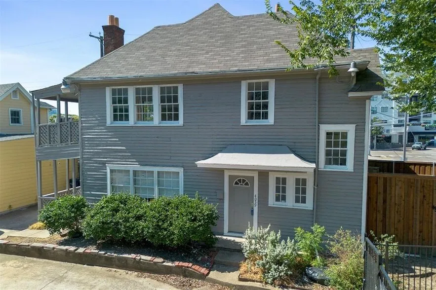Two-story residence featuring shingle siding, a front entry with a small overhang, and multiple multi-pane windows