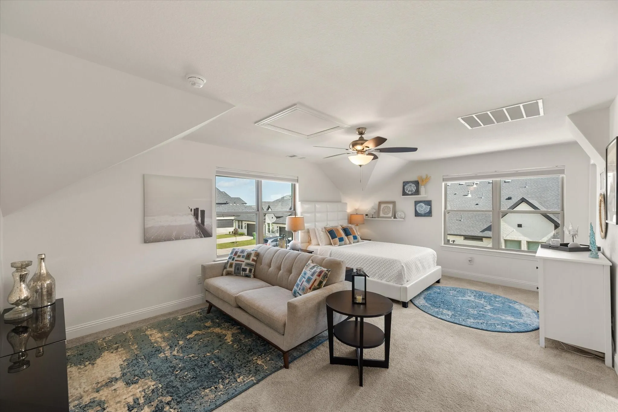 Upstairs Garage Studio Bedroom featuring multiple windows, carpet floors, a ceiling fan, and vaulted ceiling