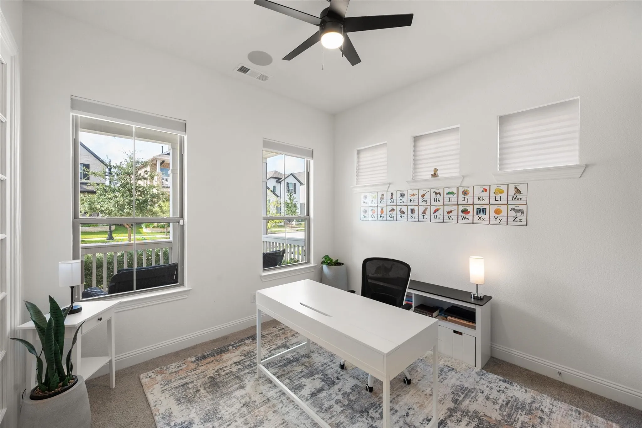 Carpeted home office downstairs with baseboards and ceiling fan