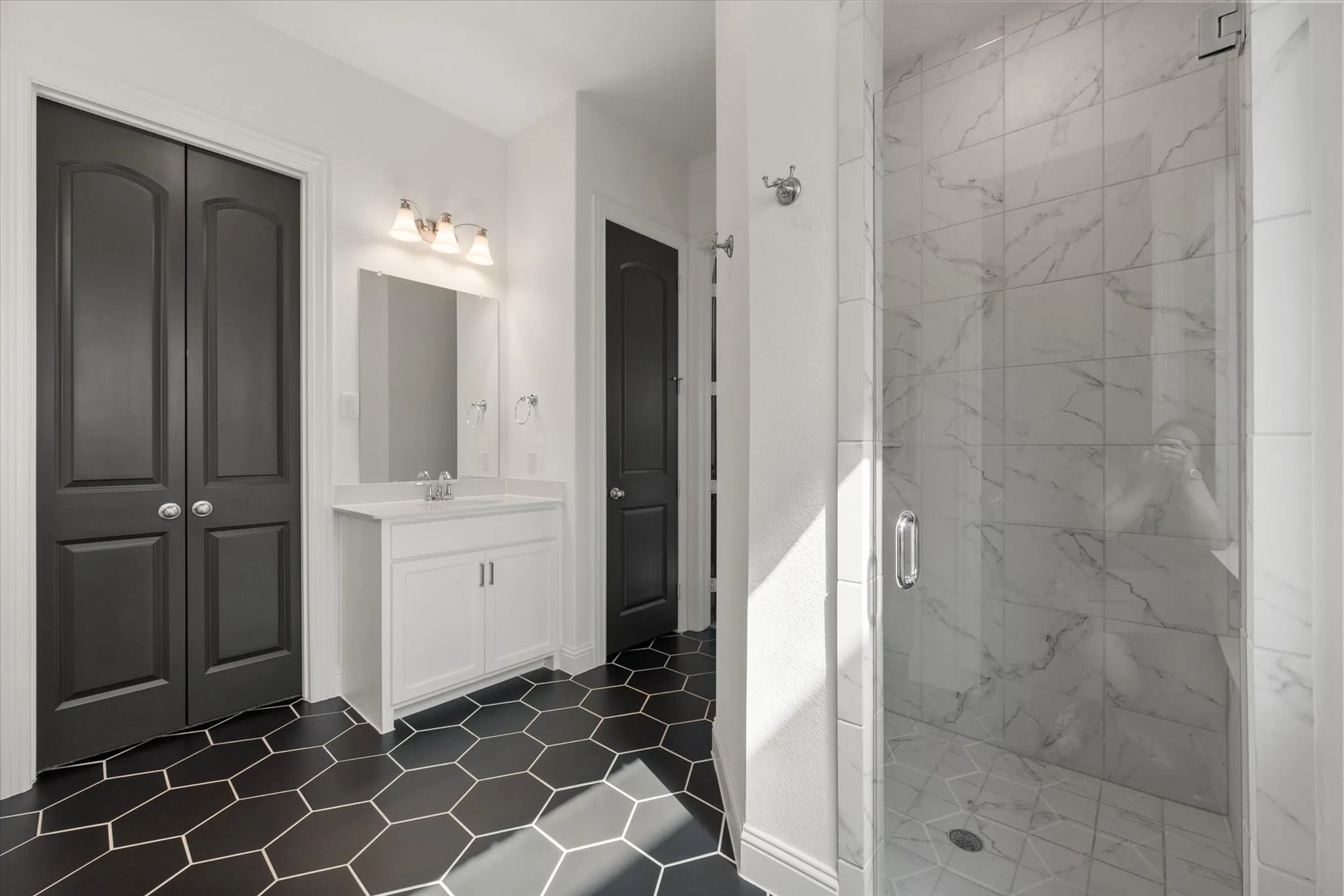 Full bathroom with vanity, a marble finish shower, a closet, and dark tile patterned floors