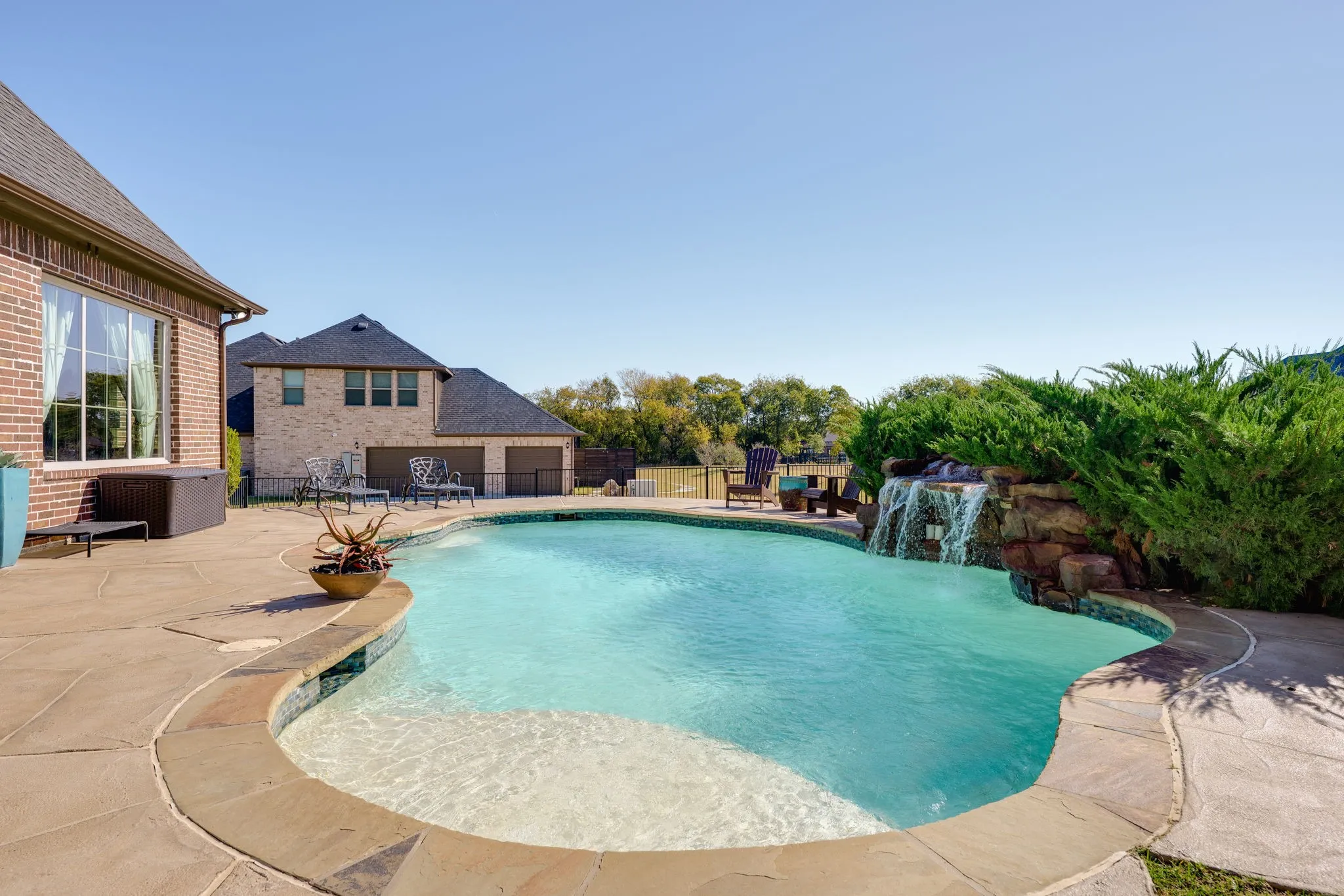 Outdoor pool with a fenced backyard and a patio