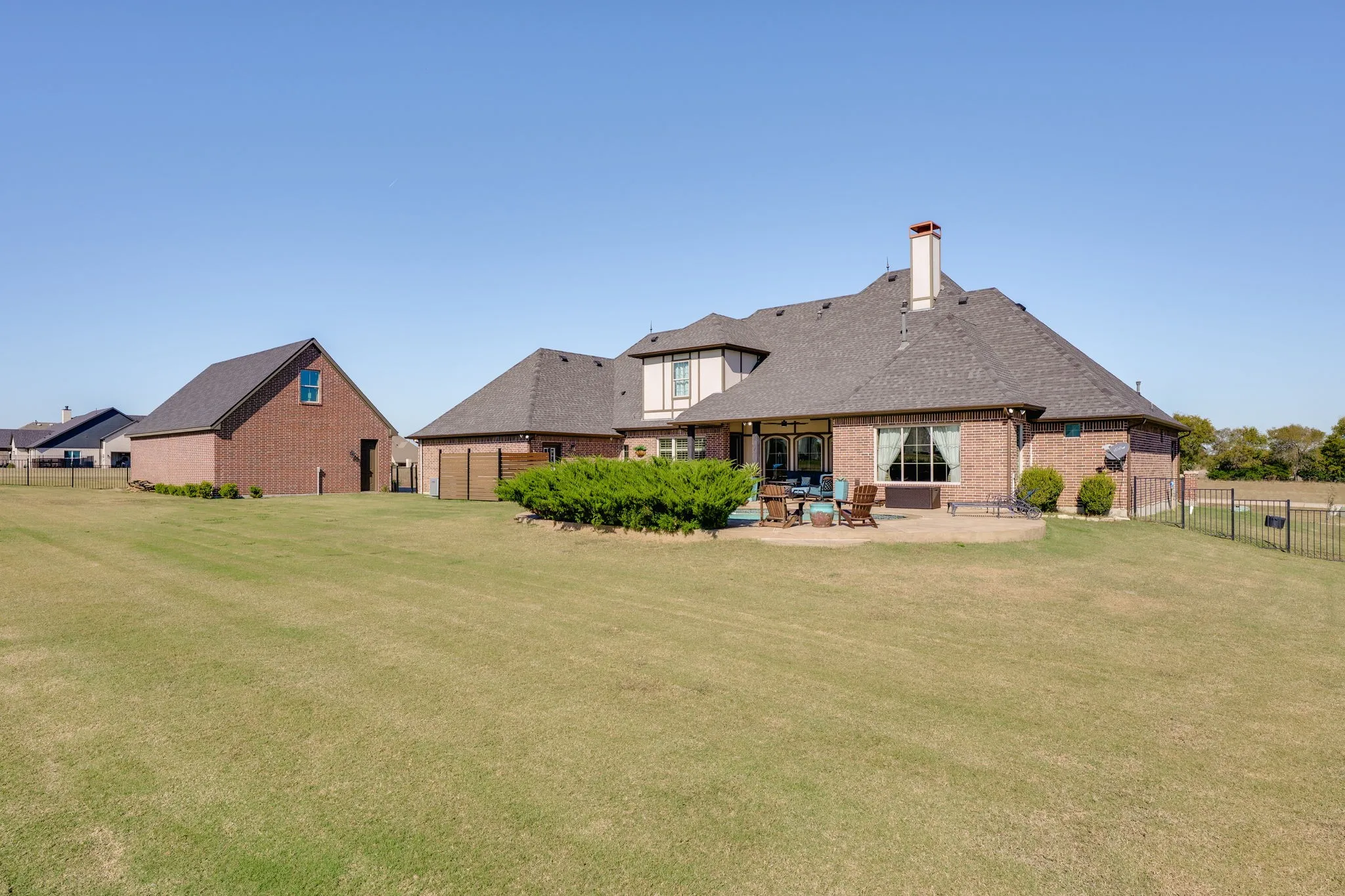 Back of house featuring a fenced backyard, a chimney, a patio area, and a garage