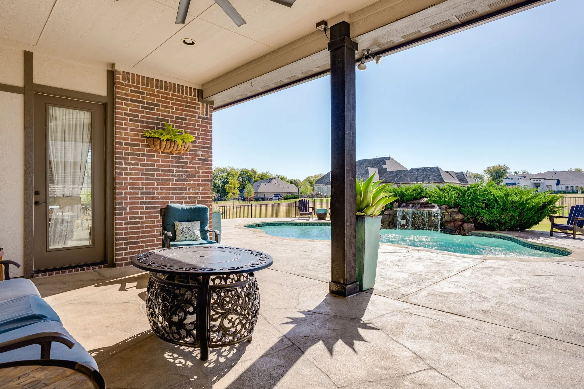 Fenced backyard with a patio, a ceiling fan, and a fire pit