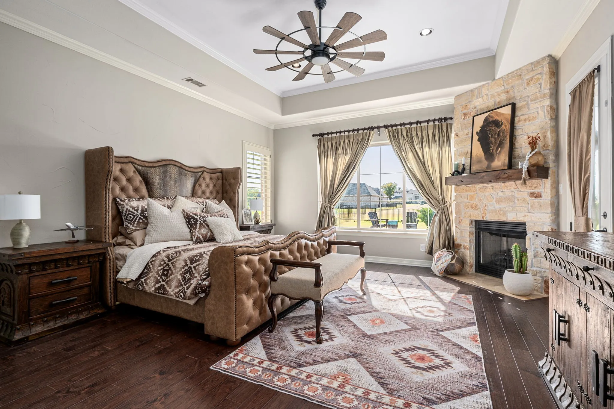 Bedroom with ornamental molding, a fireplace, dark wood-style floors, and a ceiling fan