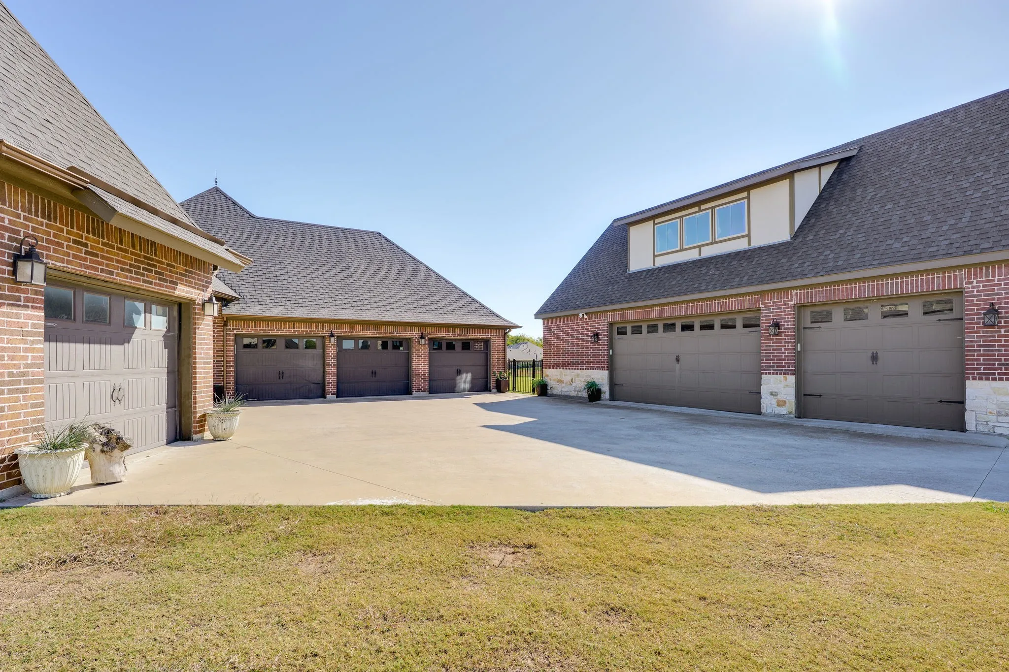 View of side of property featuring roof with shingles, a garage, driveway, and a lawn