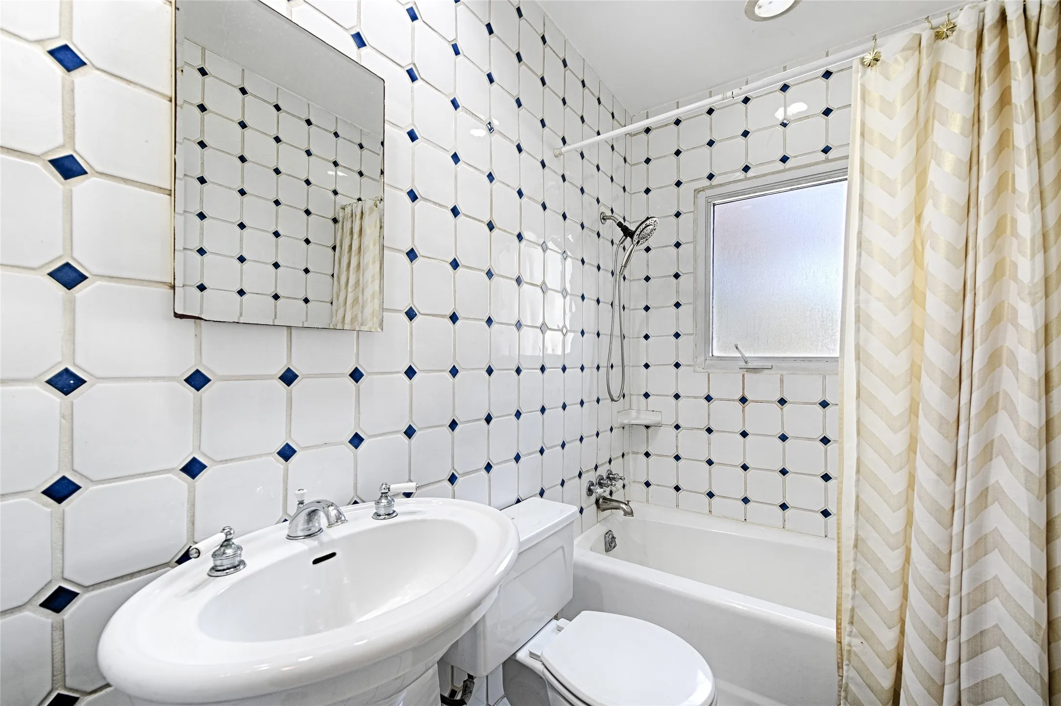 Full bathroom with fully tiled walls and shower / bath combo