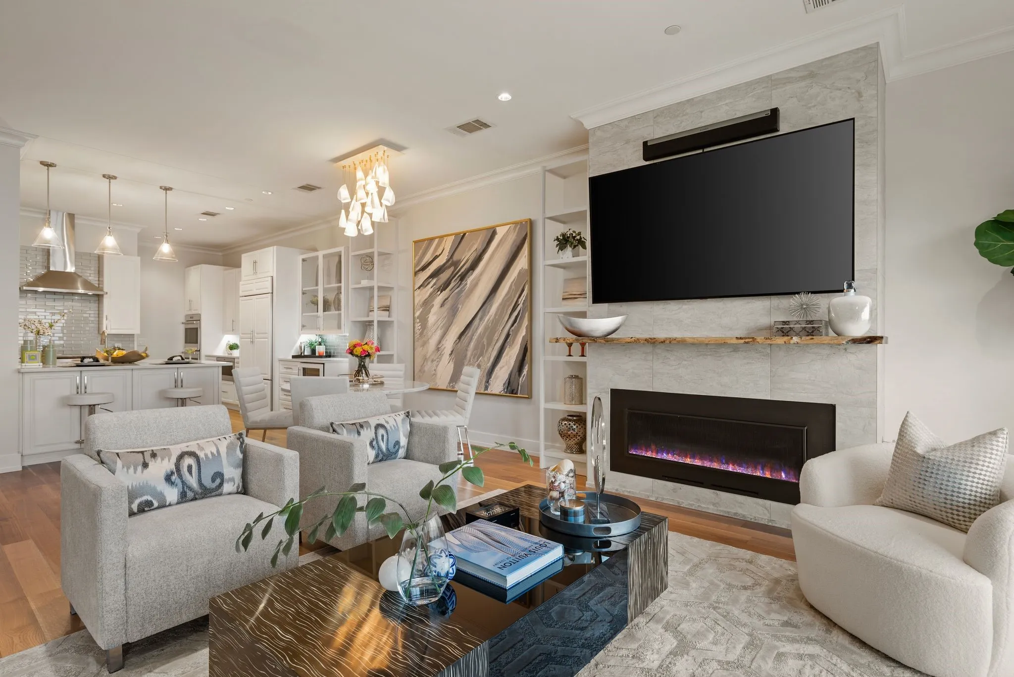 Living room with a fireplace, built in shelves, crown molding, and wood finished floors