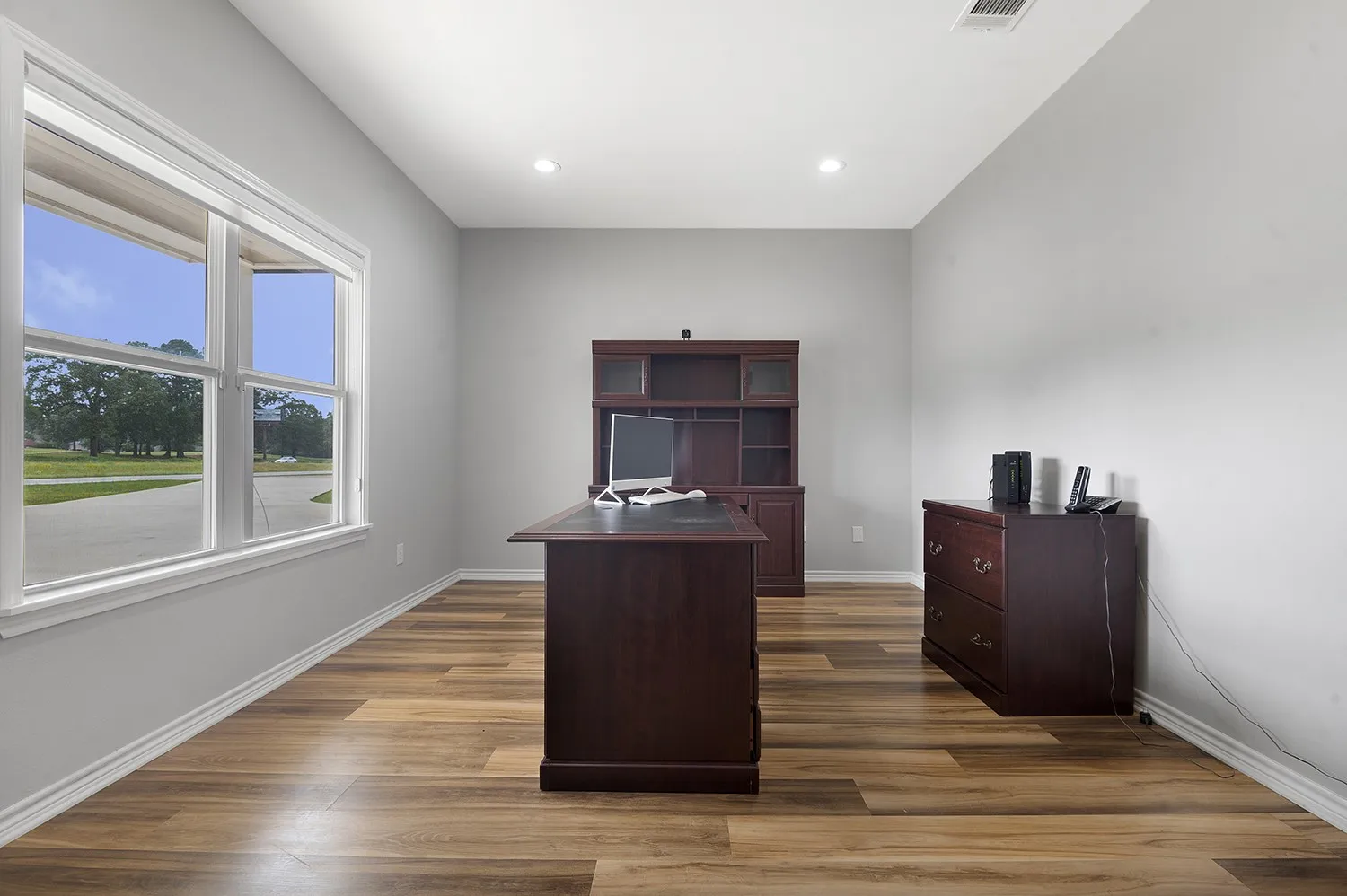 Office space 1 with dark wood-type flooring and recessed lighting