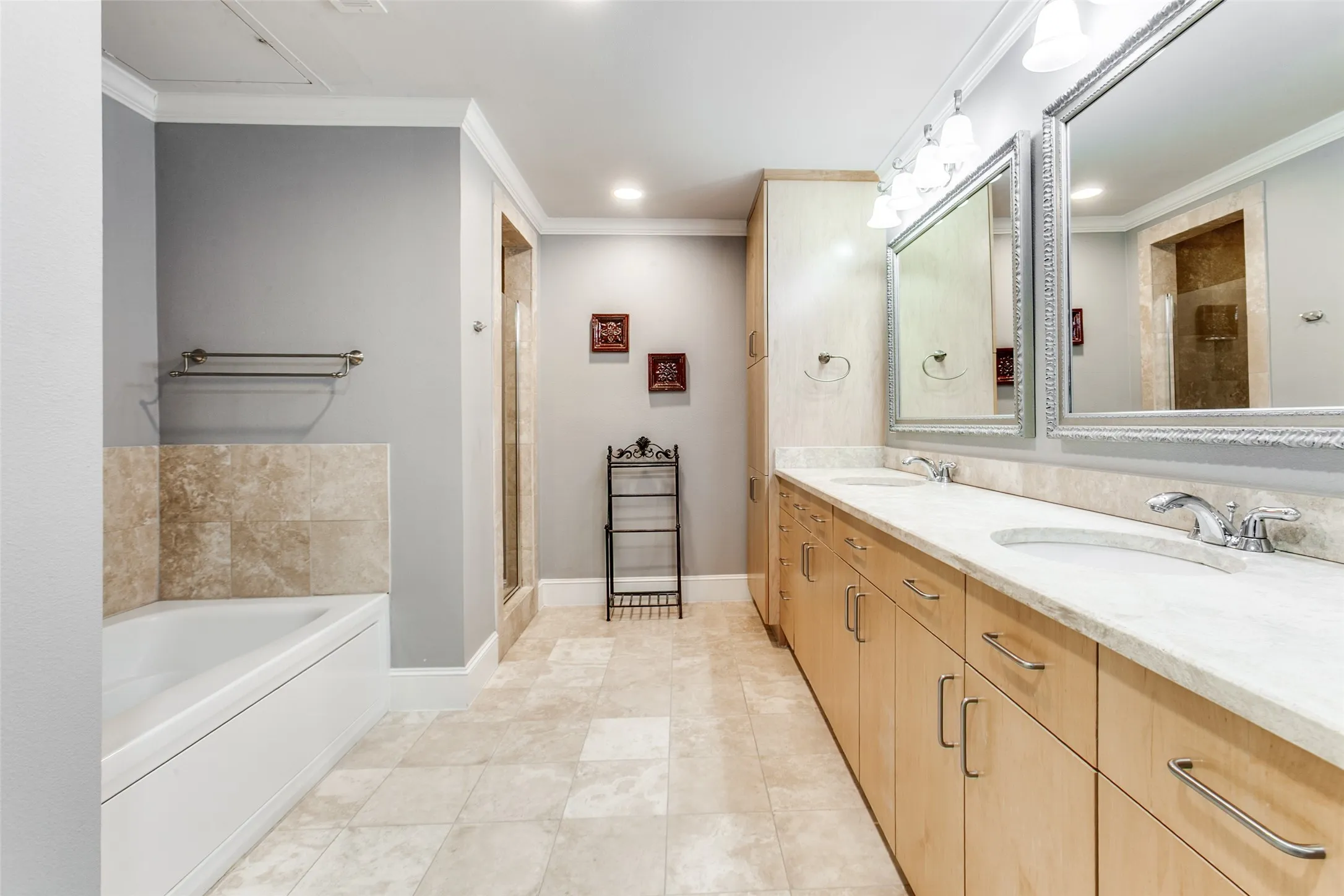 Dual sinks, storage, linen closet, travertine tile.